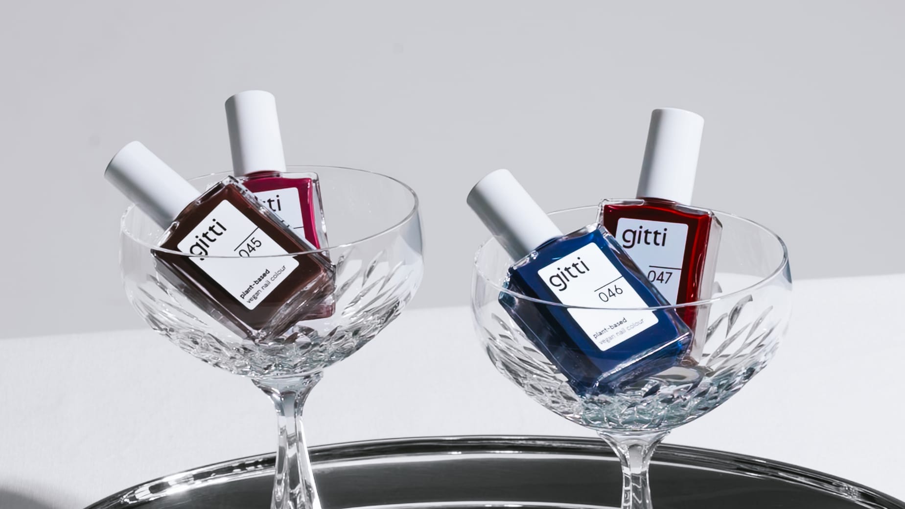 gitti Dark Bloom Nagellack Collection in Champagner Gläsern auf Chrome Tablett