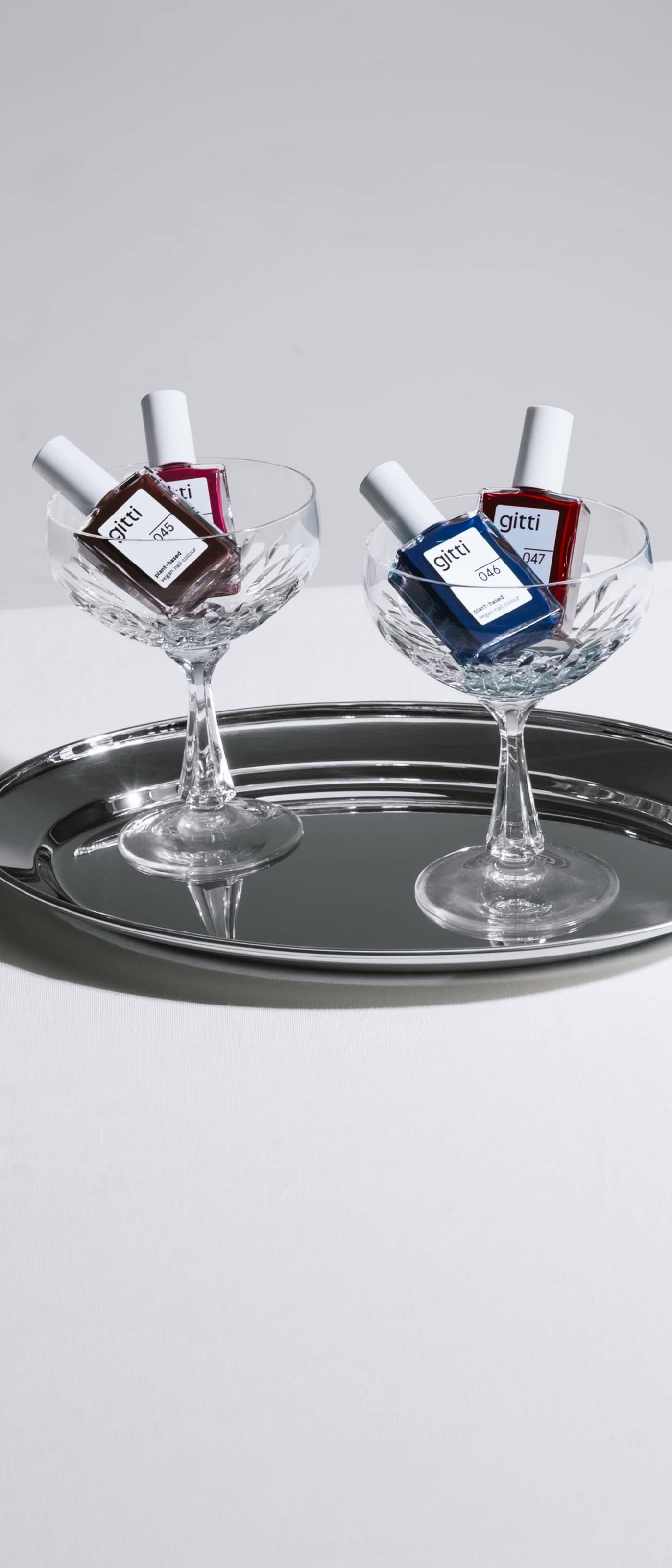 gitti Dark Bloom Nagellack Collection in Champagner Gläsern auf Chrome Tablett