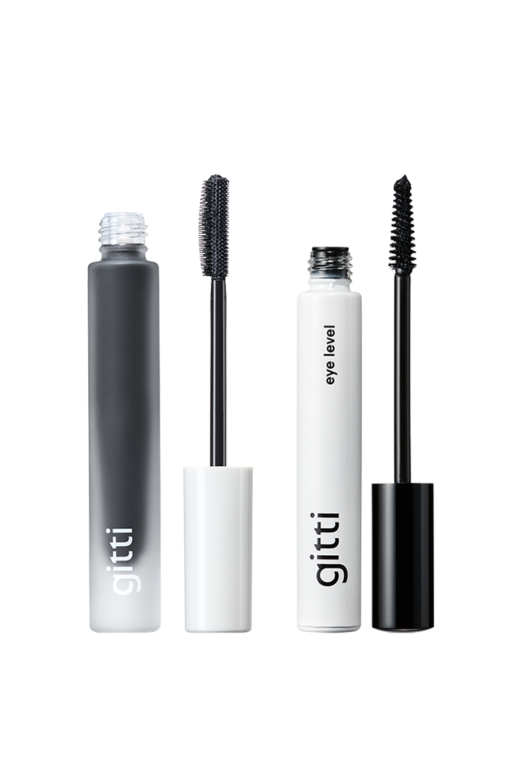 Zwei geöffnete Tuben des Lash Duo in einer eleganten schwarz-weißen Verpackung mit sichtbaren Mascarastäbchen vor einem klaren weißen Hintergrund.