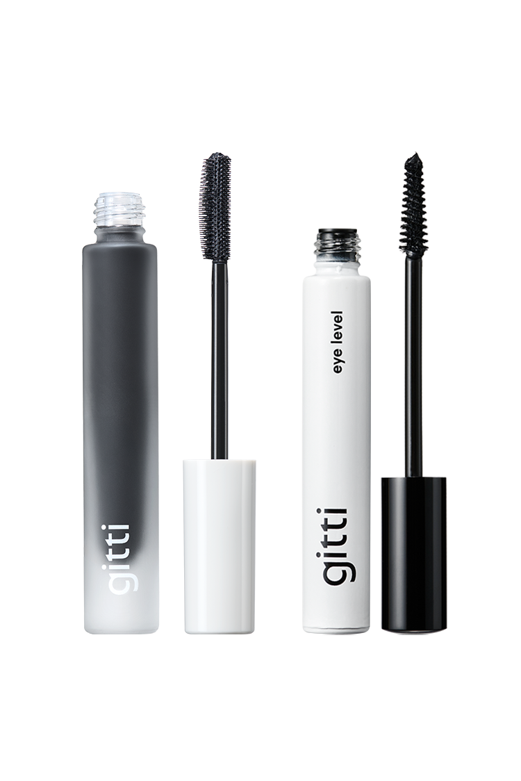 Das Lash Duo enthält zwei Gitti Mascaras: eine in einer mattgrauen Tube mit weißer Kappe, die andere in einer weißen Tube auf Augenhöhe" mit schwarzer Kappe - zusammen bilden sie ein stilvolles und vielseitiges Mascara-Set.