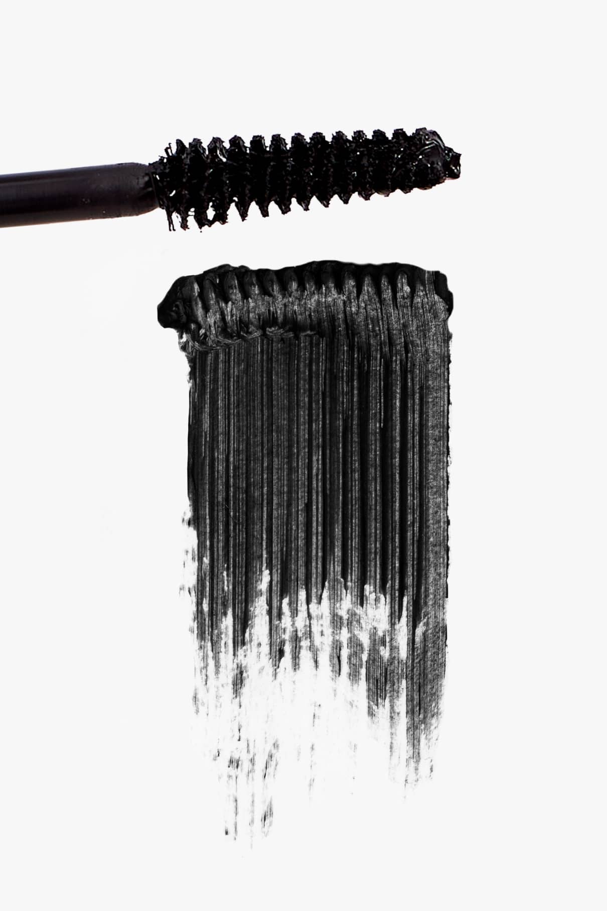 Die schwarze Mascara-Wand der Eye Level Volumen-Mascara zieht einen kräftigen Strich auf weißem Hintergrund und sorgt so für ein natürliches Finish.