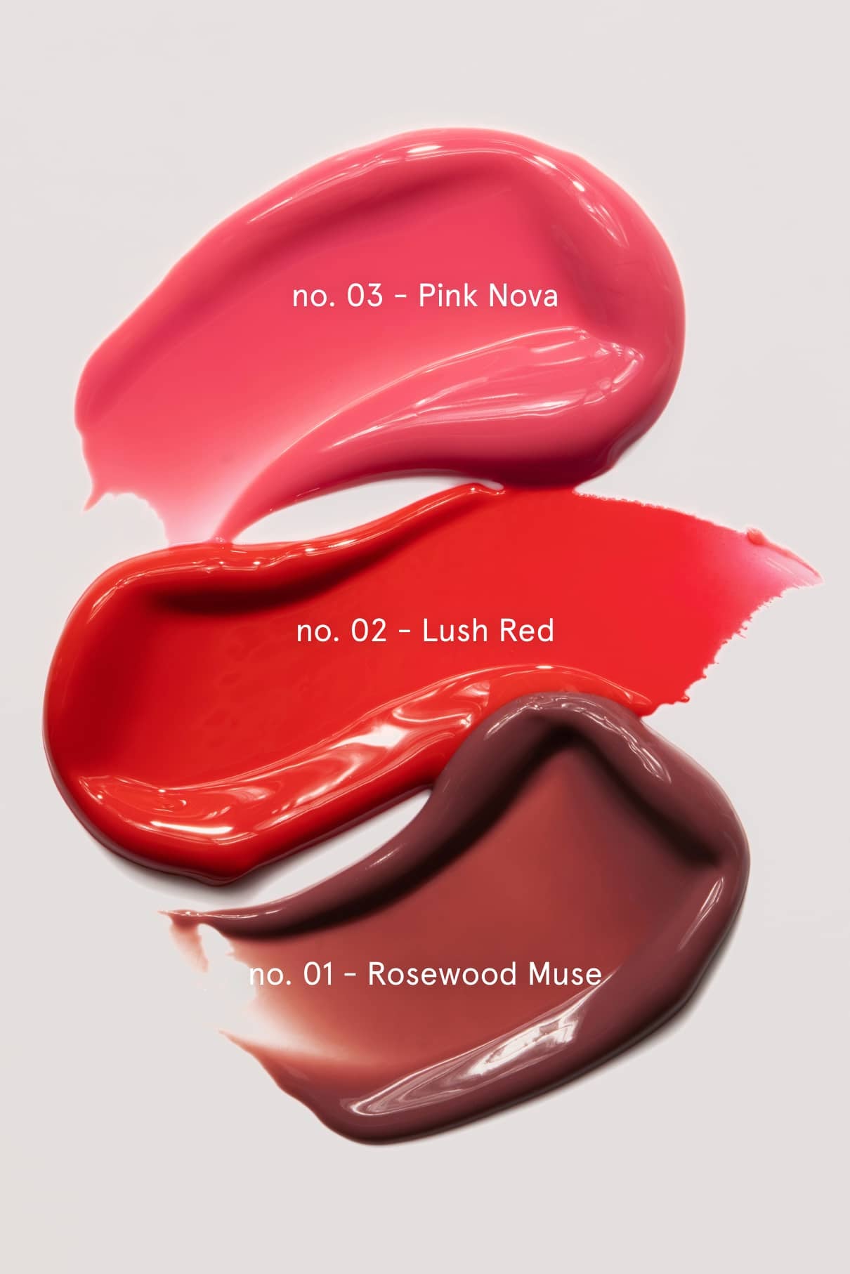 Die drei Tupfer Nr. 03 Pink Nova (oben, rosa), Nr. 02 Lush Red (Mitte, rot) und Nr. 01 Rosewood Muse (unten, bräunlich-mauve) des Signature Sets ergänzen unsere Lip Glaze für ein makelloses Finish auf weißem Hintergrund.