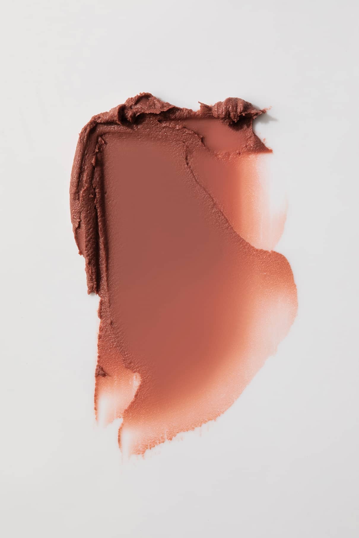 Ein Abstrich von Lip Sync Refill Nr. 01, ein mattes, warmes, braunes Make-up mit rötlichem Unterton - möglicherweise ein Lippenstift oder Rouge - wird auf eine weiße Fläche aufgetragen.
