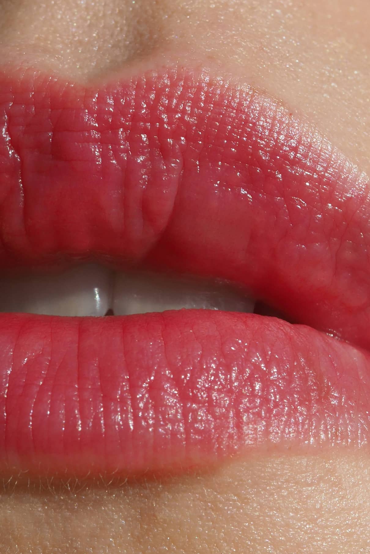 Nahaufnahme von Lippen, die mit Lip Sync Refill Nr. 02, ein natürlicher Rosaton, ideal für kühle Hauttypen oder Liebhaber pinkfarbener Tendenzen, zeigt strukturierte Ober- und Unterlippen mit einem Hauch von sichtbaren Zähnen.