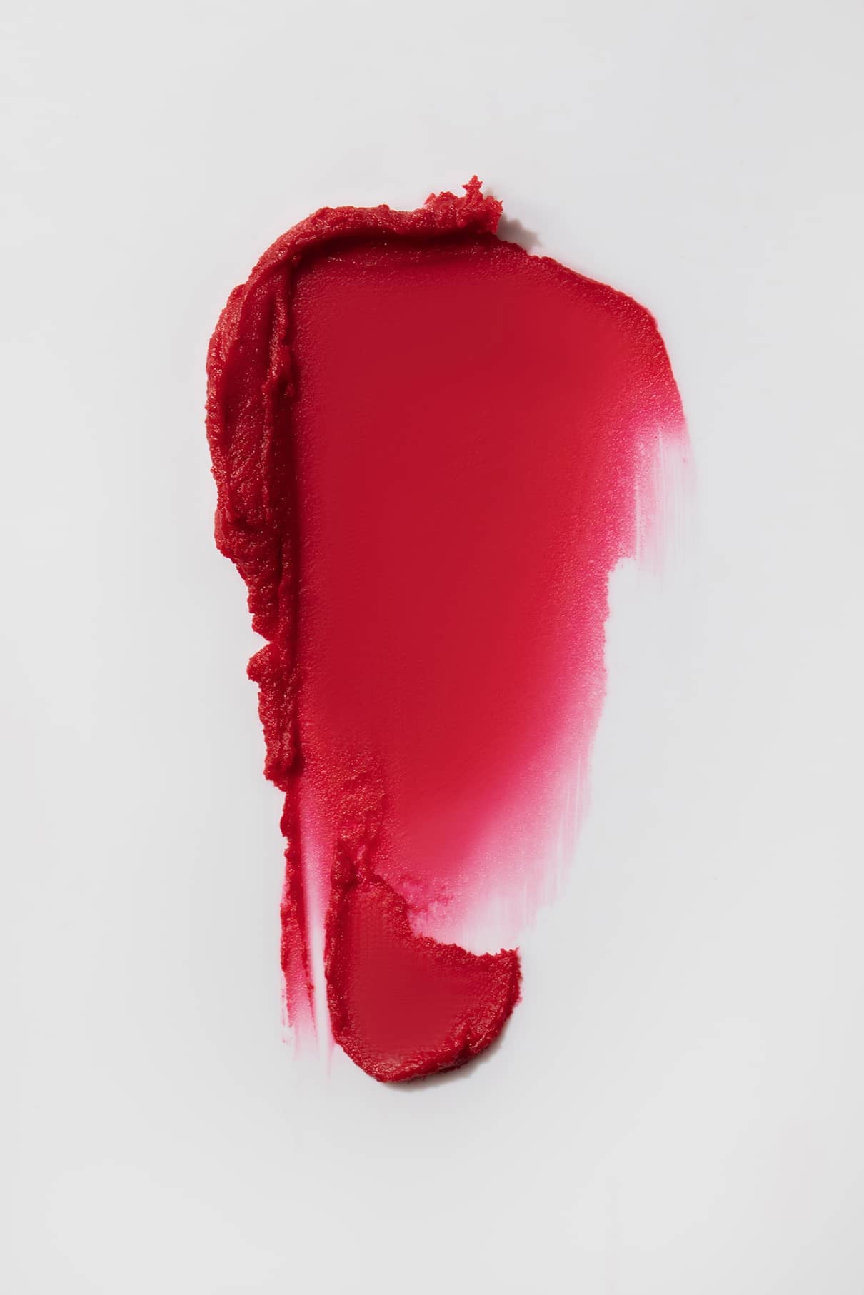 Ein Abstrich des Lip Sync Refill no. 02 Lippenstift, ein Beerenrot mit rosafarbenen Untertönen, auf weißem Hintergrund; seine strukturierten, ungleichmäßigen Ränder machen ihn ideal für kühle Hauttöne.