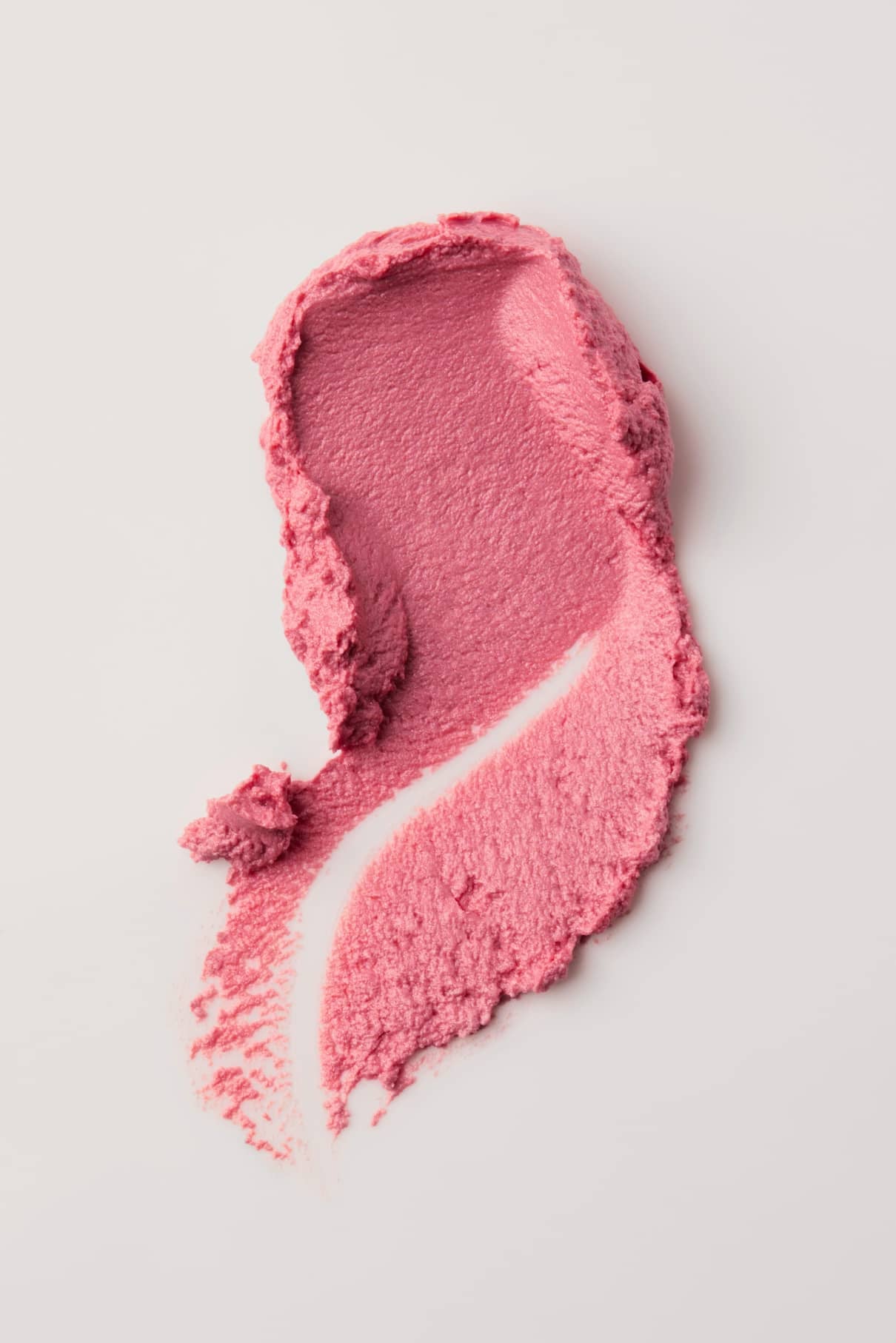 Velvet Cheeks no. 03, ein silikonfreies pastell-rosa Mousse Rouge, wird auf eine weiße Fläche aufgetragen, um seine Textur und die sichtbaren Pinselspuren zu zeigen.