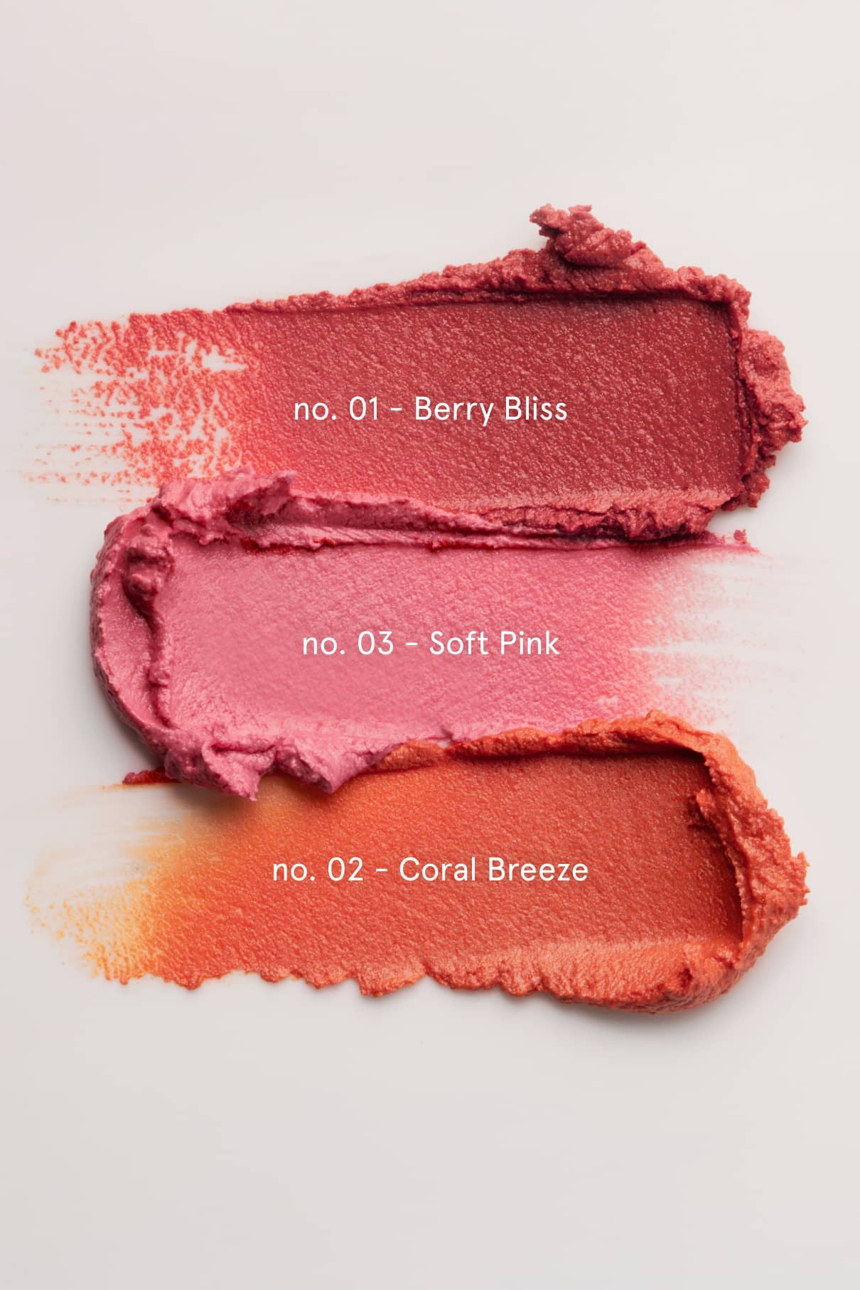 Drei Swatches von Velvet Cheeks no. 01 silikonfrei Mousse-Blush sind abgebildet: Berry Bliss (oben, tiefes Beerenrot), Soft Pink (Mitte, helles Rosa) und Coral Breeze (unten, Koralle) auf weißem Hintergrund.