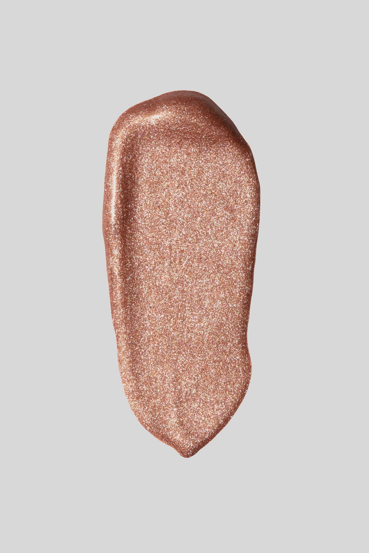 Ein Klecks schimmerndes Flüssig-Make-up in Roségold aus dem Visionist Celebration Duo vor einem schlichten hellgrauen Hintergrund, der die raffinierte Farbauswahl unterstreicht.