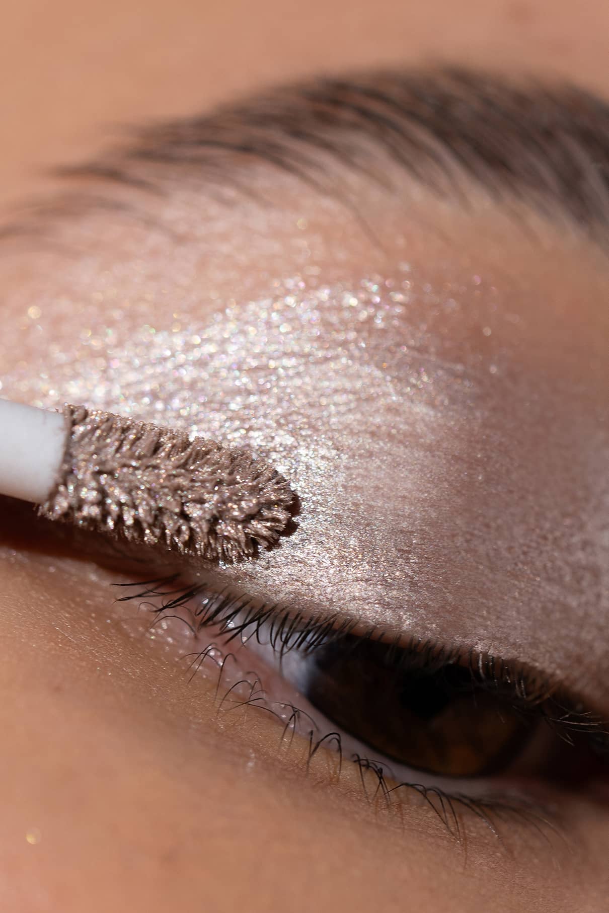 Nahaufnahme eines Augenlids mit Metallic-Lidschatten aus dem Eye Colour Set, der mit einem Pfoten-Applikator aufgetragen wird.