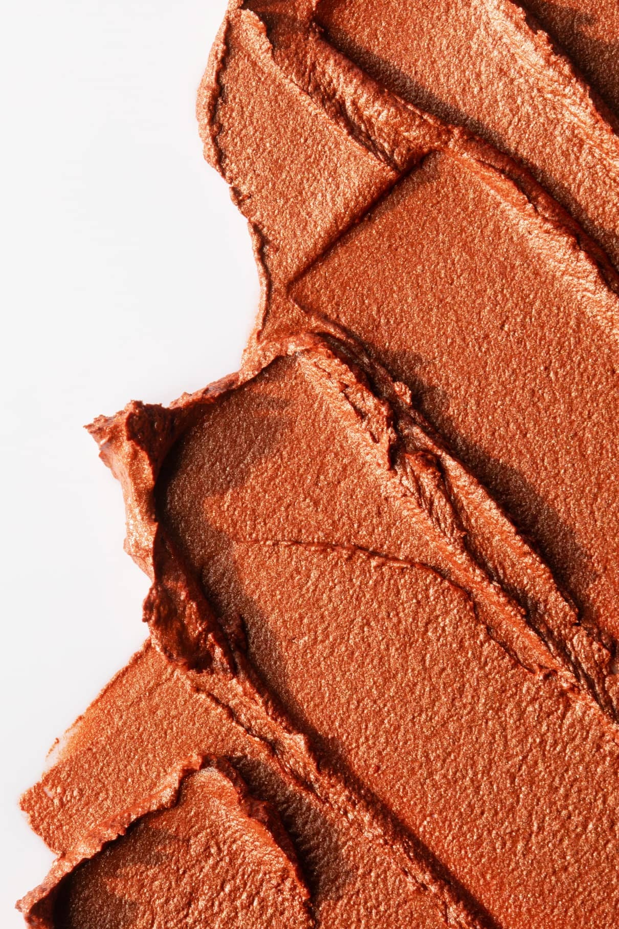 Nahaufnahme von Velvet Cheeks no. 04, ein metallisches, kupferfarbenes Mousse Rouge mit weißem Hintergrund - ideal für ein sonnengeküsstes Finish.