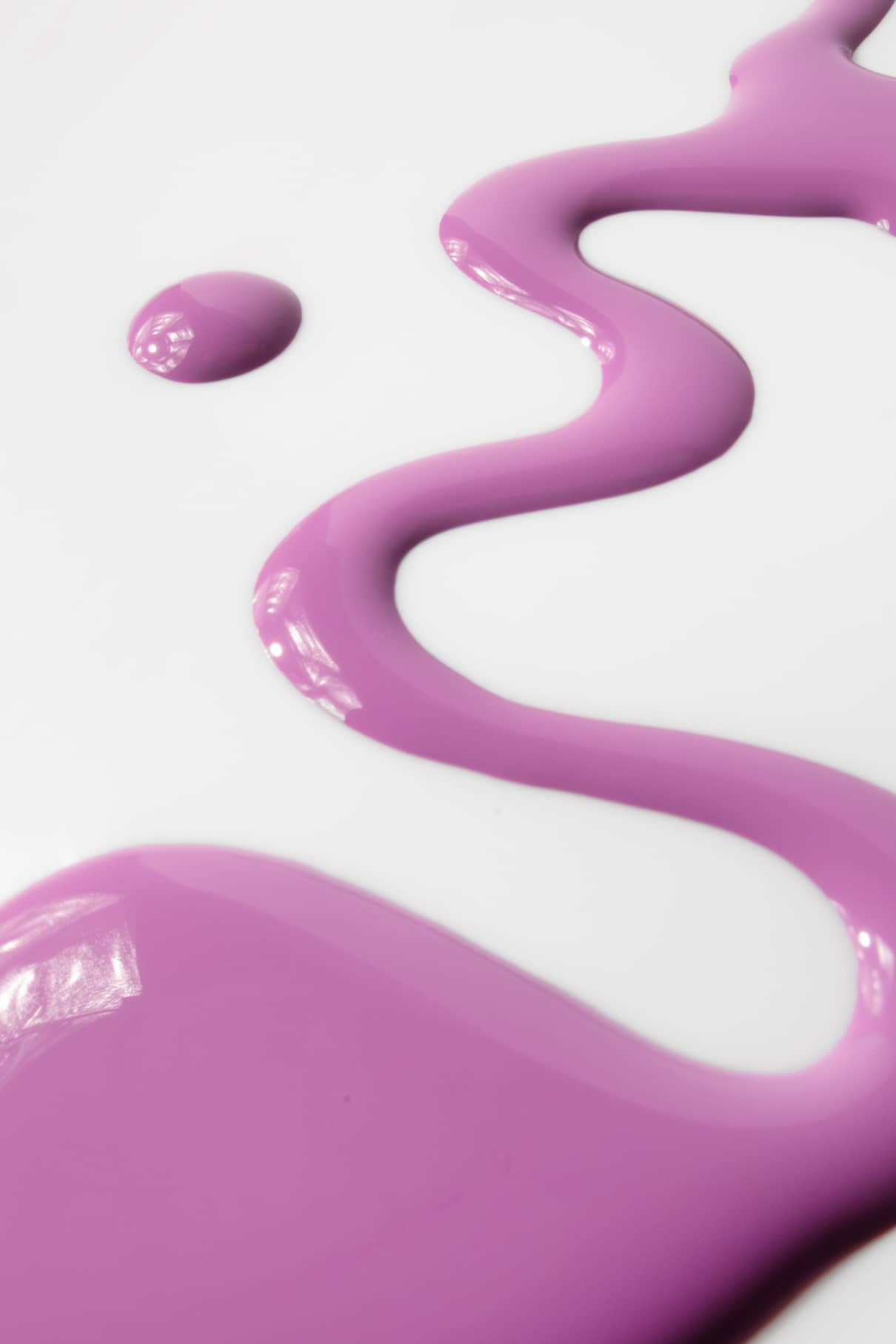 Eine Wellenlinie, ein kleiner Punkt und eine große Pfütze aus gitti kids no. 07 kinderfreundliche Nagelfarbe in Lila sind auf einer glatten weißen Fläche verteilt.