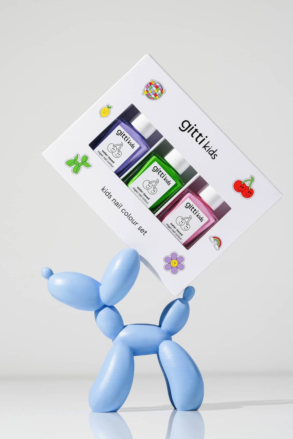 Eine blaue Ballonhundeskulptur hält eine Schachtel mit der Aufschrift Little Artist Set, die vier Kindernagelfarben - darunter La La Lilac - und verspielte Sticker für zusätzlichen Green Planet-Spaß enthält.