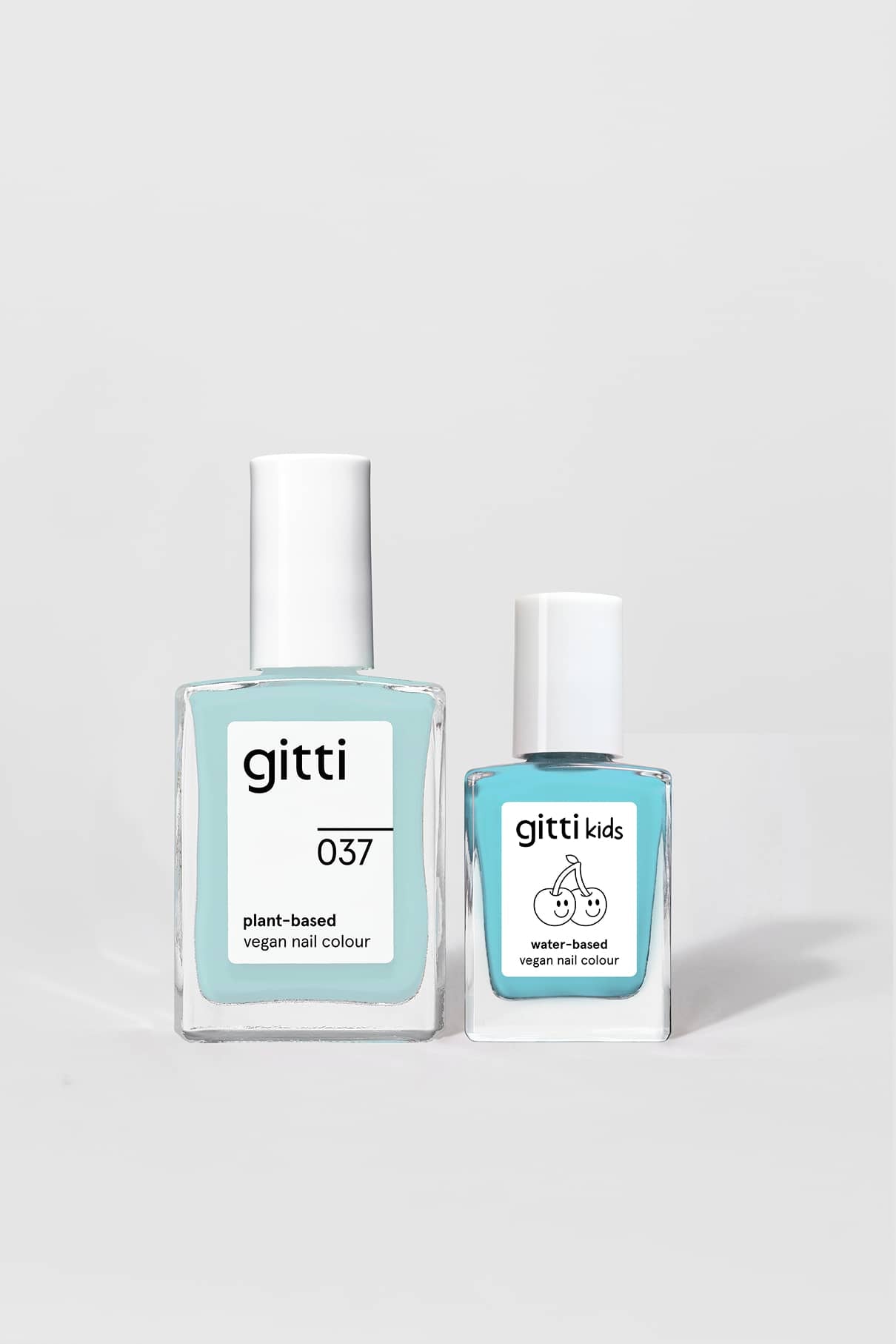 Zwei blaue Nagellackflaschen, das Mini & Me Set, stehen Seite an Seite - eine auf pflanzlicher Basis für Erwachsene und eine auf Wasserbasis für Kinder - und bilden so ein perfektes Farbset für jedes Alter.