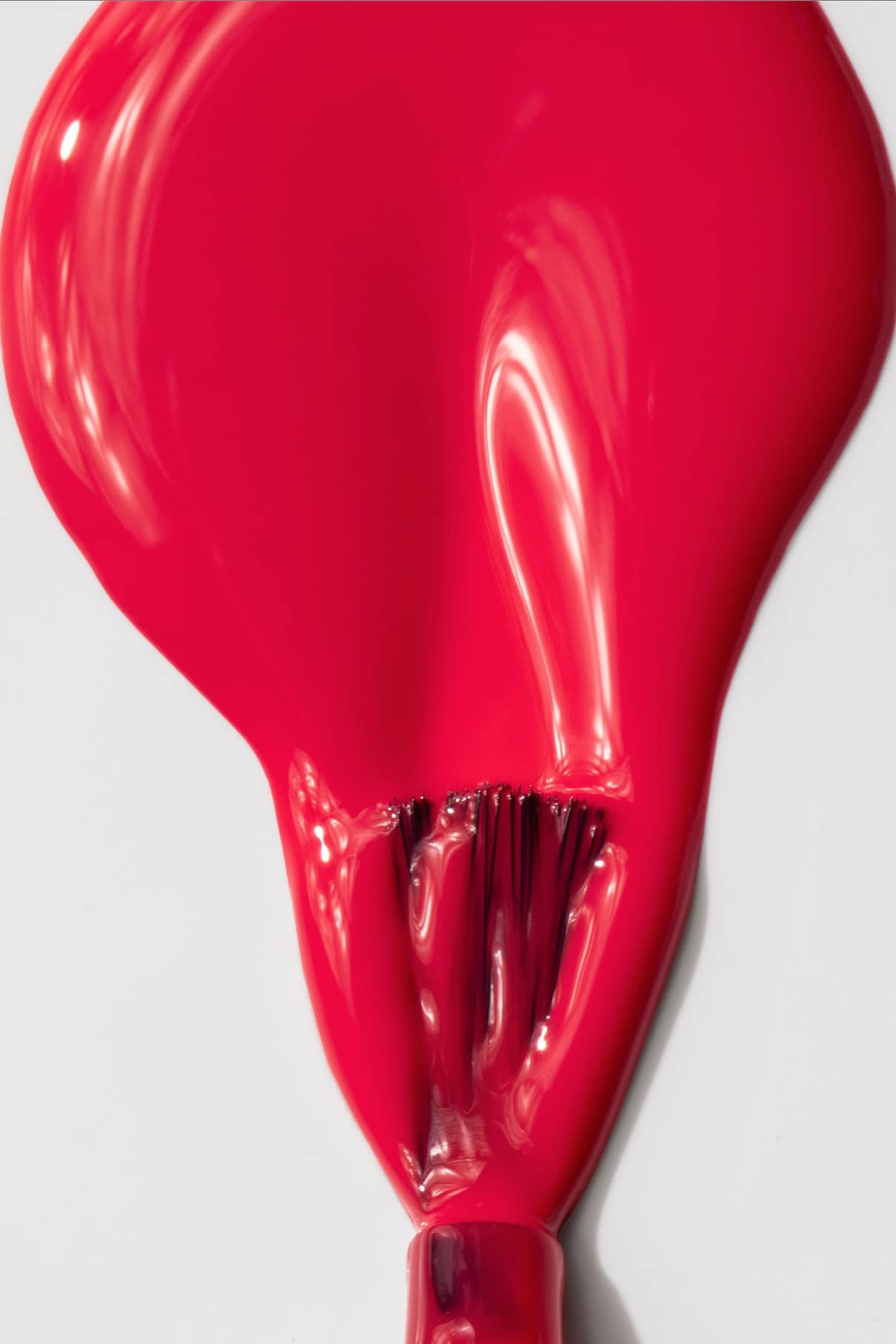Gitti no. 006, ein roter Nagellack mit kräftigem Rot und rosafarbenem Unterton, ist verschüttet und teilweise auf einer weißen Fläche verteilt, mit sichtbaren Pinselstrichen am unteren Rand des Bildes.