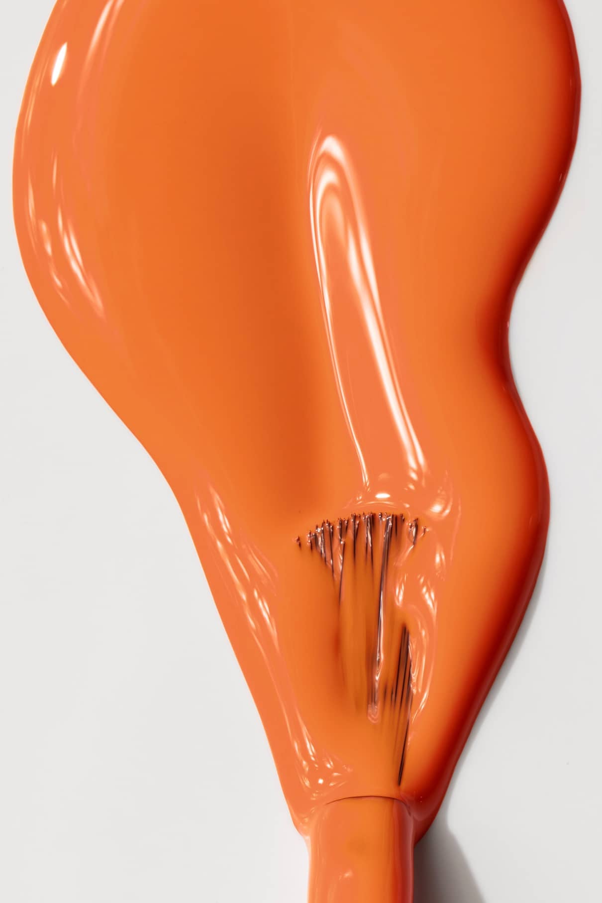 Eine Nahaufnahme von gitti no. 008, ein leuchtend orangefarbener Pinselstrich mit glänzendem Finish und sichtbaren Borstenspuren auf weißem Hintergrund.