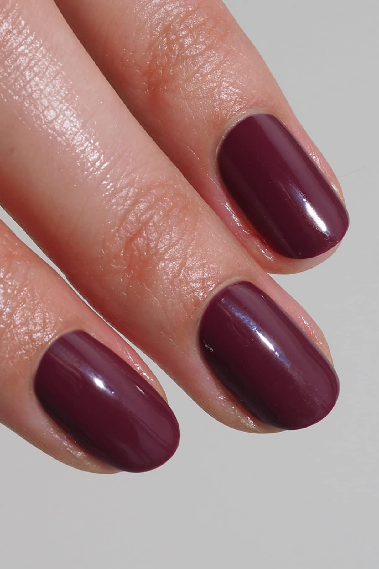 Nahaufnahme von drei Fingern mit sauber geformten Nägeln, die in gitti no. 016, ein leuchtendes Beerenrot, das an einen trendigen Lippenstift erinnert.
