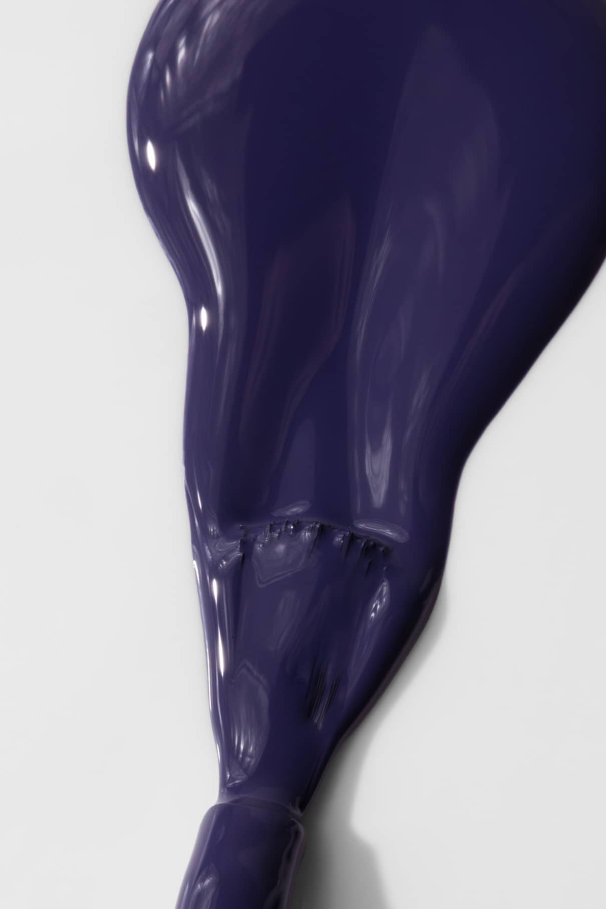 Eine Nahaufnahme eines dicken, glänzenden Abstrichs von gitti no. 018, ein dunkler Violett-Ton mit einem Hauch von tiefem Blau, gemischt auf einer weißen Fläche.