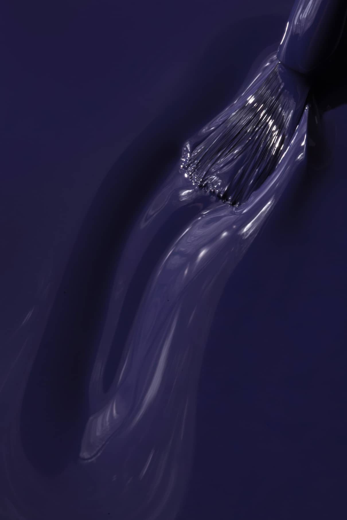 Nahaufnahme eines Pinsels, mit dem gitti no. 018, eine klare Flüssigkeit, auf eine Fläche auf, auf der sich tiefes Blau und Violett wunderbar vermischen.
