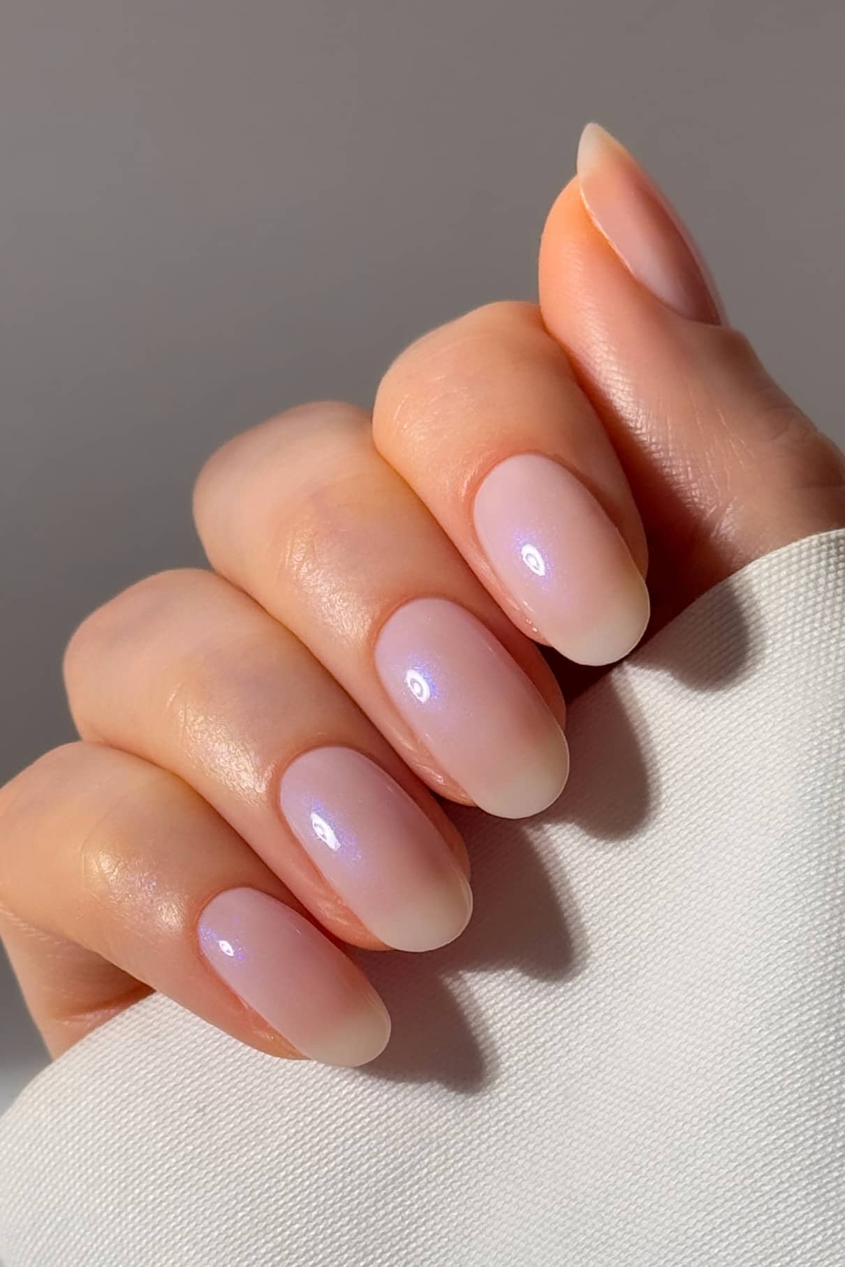 Nahaufnahme einer Hand mit mittellangen, mandelförmigen Nägeln, die mit gitti Nr. 025 in glänzendem, halbtransparentem Pink Ombré lackiert wurden. 025.