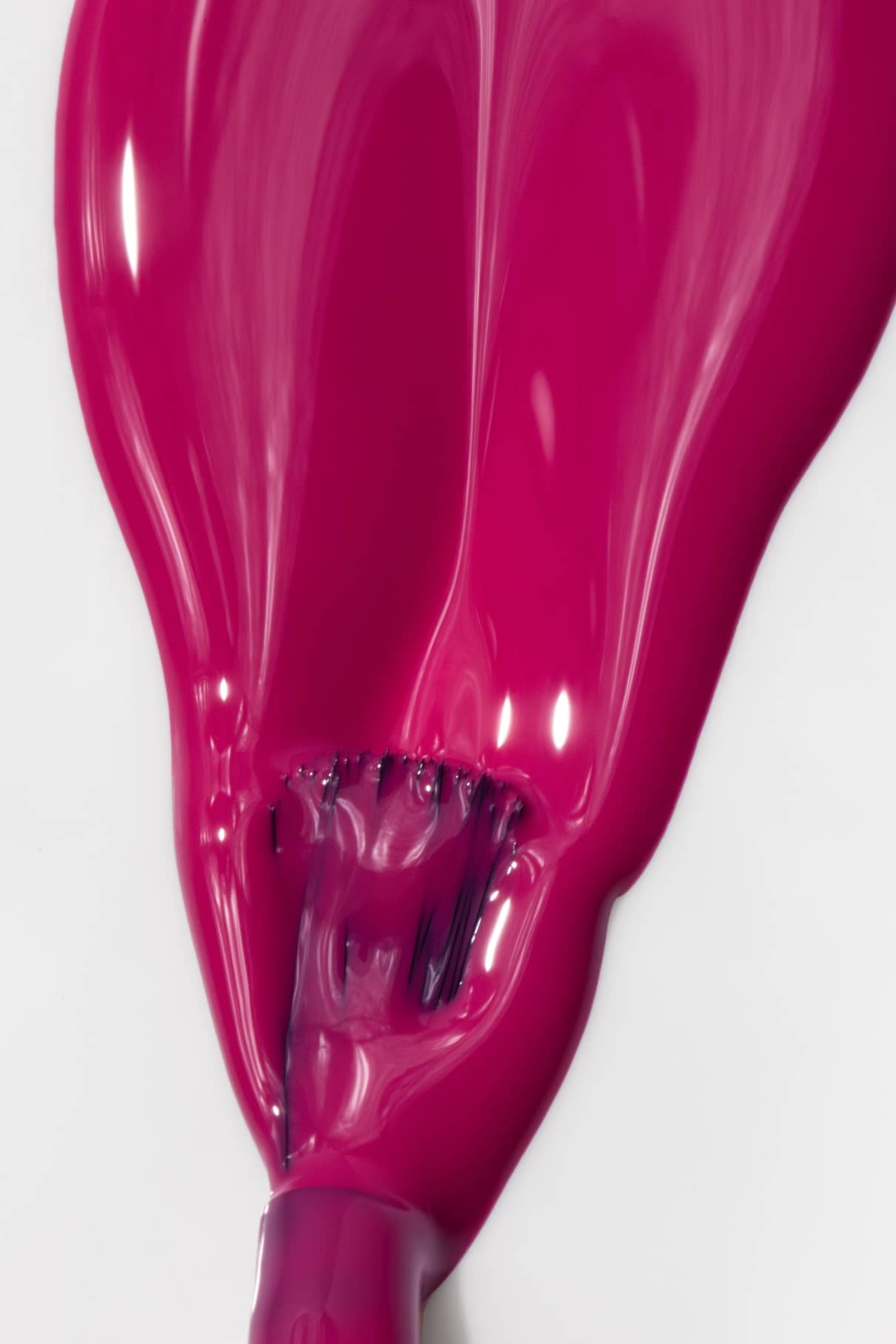 Gitti no. 027, ein leuchtend fuchsia-pinkfarbener Nagellack, ist auf einer weißen Fläche verteilt, wobei der Pinsel am unteren Rand sichtbar ist und teilweise von dem leuchtenden Lack bedeckt wird.