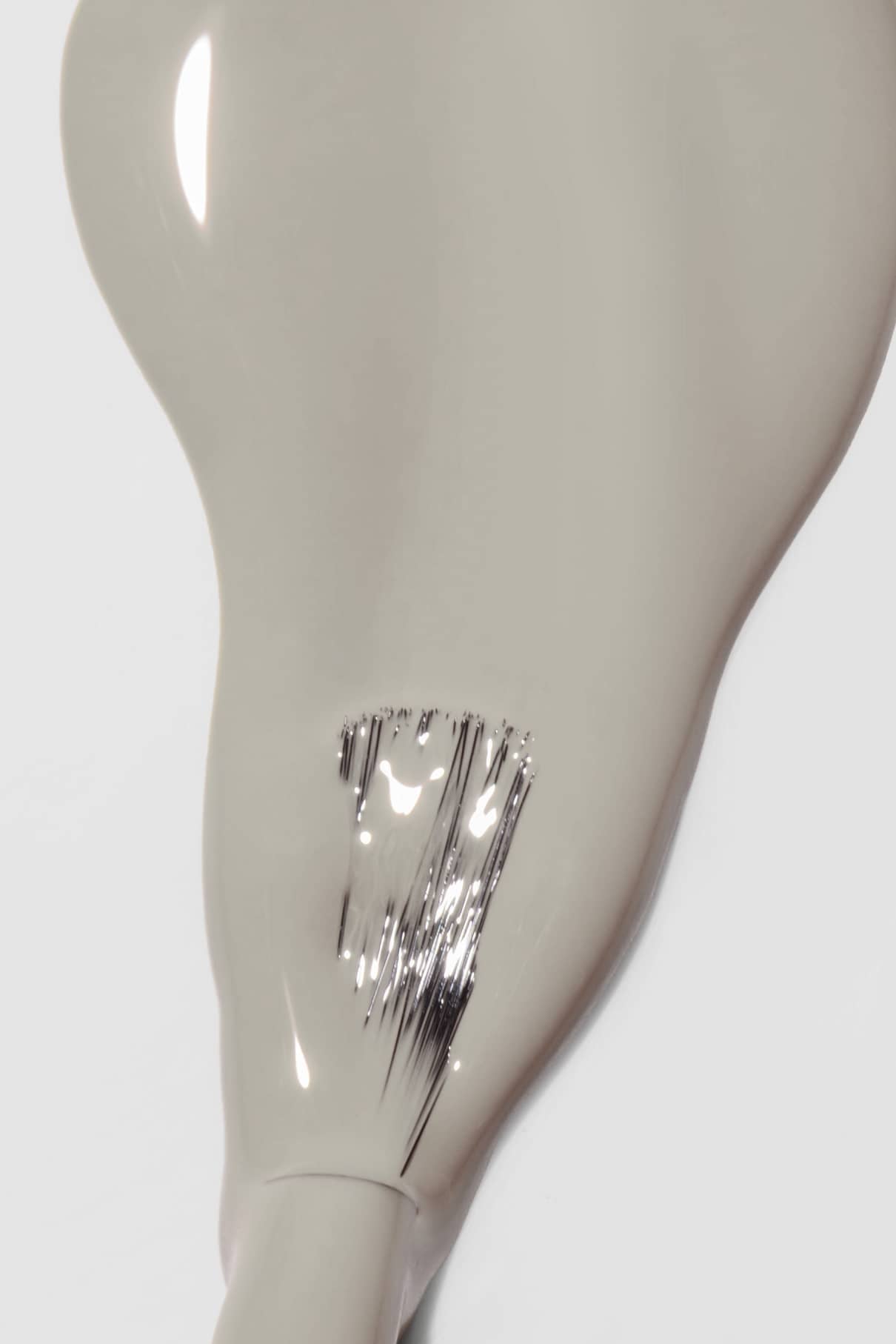 Eine Nahaufnahme von glossy gitti no. 041 zeigt eine beigefarbene Flüssigkeit mit metallisch-silbernen Pinselstrichen, die einen Hauch von weichem Taupe und grauem Unterton erkennen lassen.