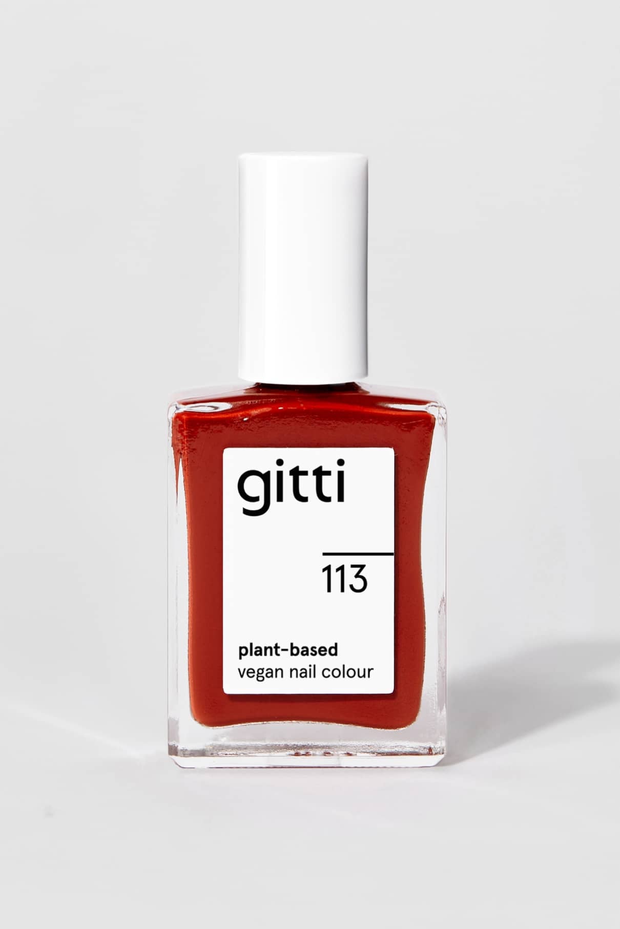 Eine Flasche gitti no. 113 pflanzlicher veganer Nagellack in braun-rot, mit weißer rechteckiger Kappe und Etikett auf einfarbigem Hintergrund. Dieser Farbton verleiht Ihren Nägeln Wärme und Stil.