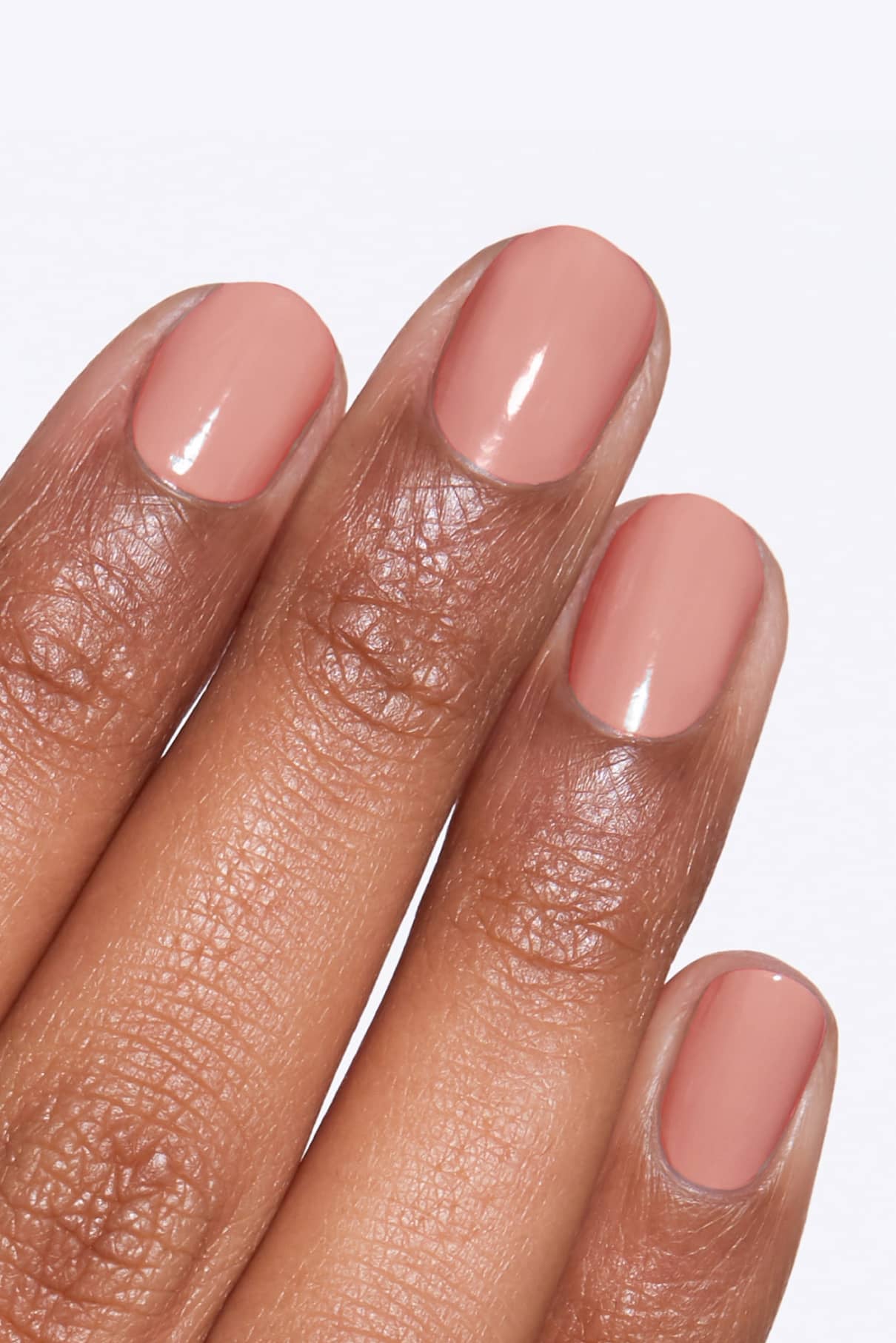 Eine Hand mit mittelbraunem Hautton zeigt sauber manikürte Nägel, die mit gitti Nr. 115 Nagellack in glänzendem Nude-Rosa lackiert sind. 115 Nagellack lackiert.