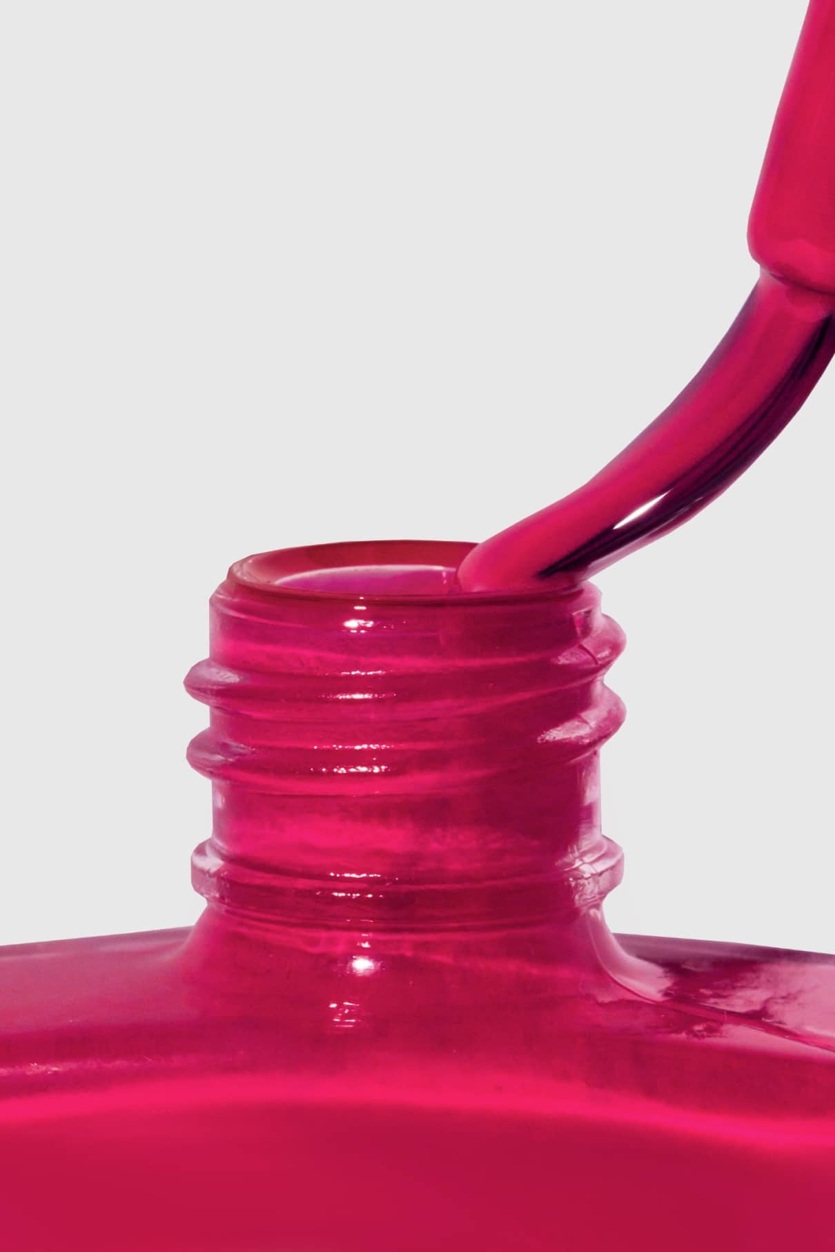 Eine Nahaufnahme zeigt den Pinsel von gitti no. 118, der in die offene, mit intensiv rotem Lack gefüllte Flasche getaucht wird, vor einem hellen Hintergrund.