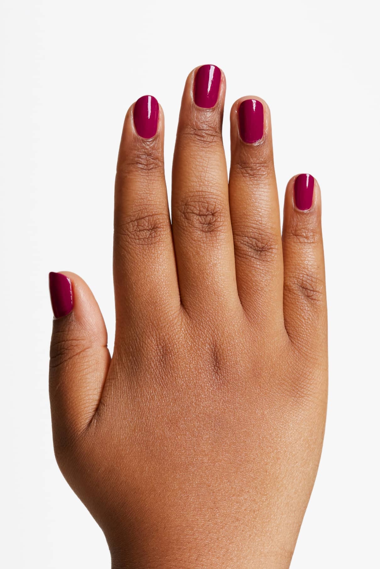 Eine Hand mit kurzen, sauber manikürten Nägeln, die in gitti no. 125, einem beerenvioletten Magenta-Ton, vor einem schlichten weißen Hintergrund gezeigt.