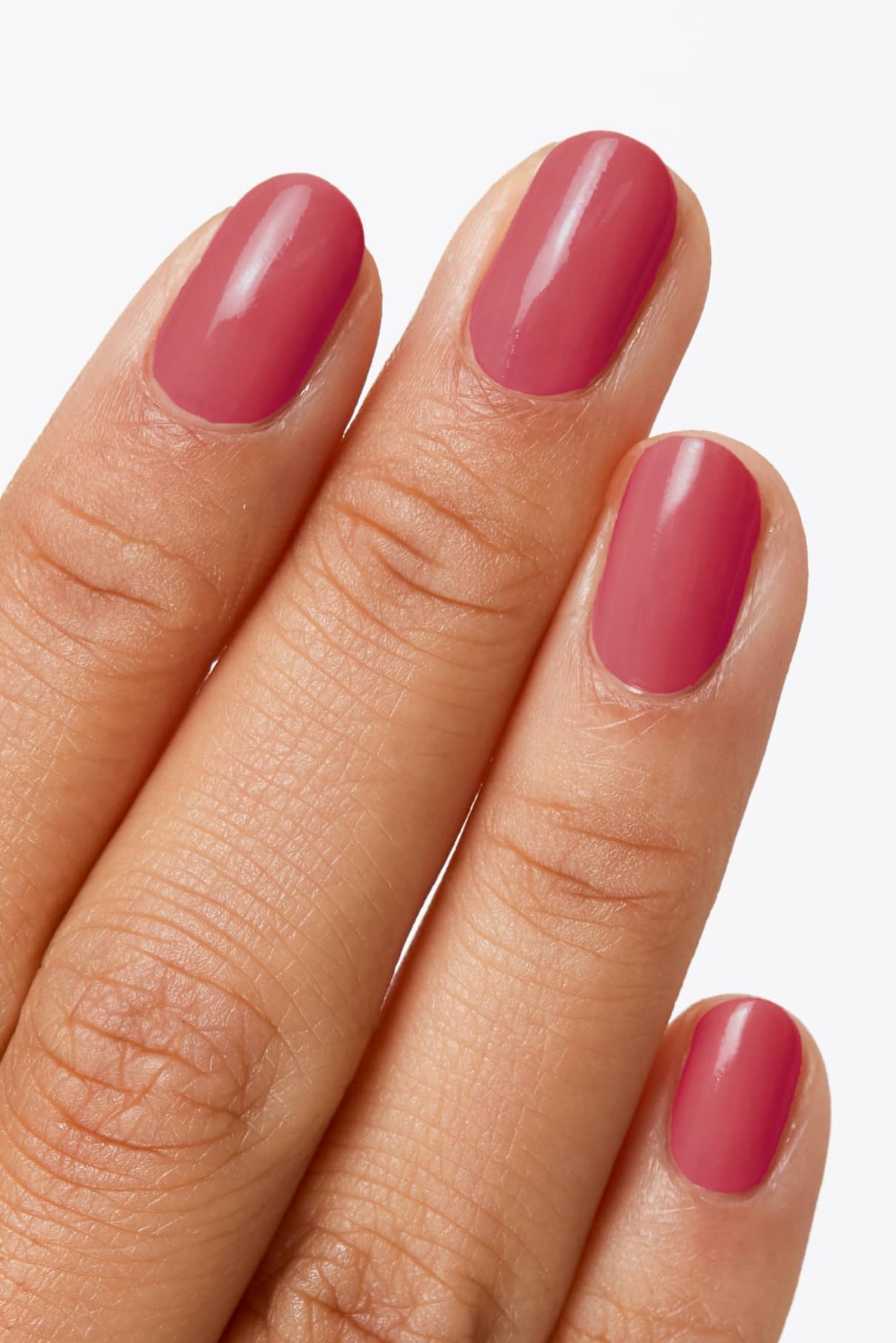 Eine Hand mit kurzen, sauber geformten Nägeln, die in gitti no. 126, einem zarten Pastellrot, leuchtet vor einem hellen Hintergrund.