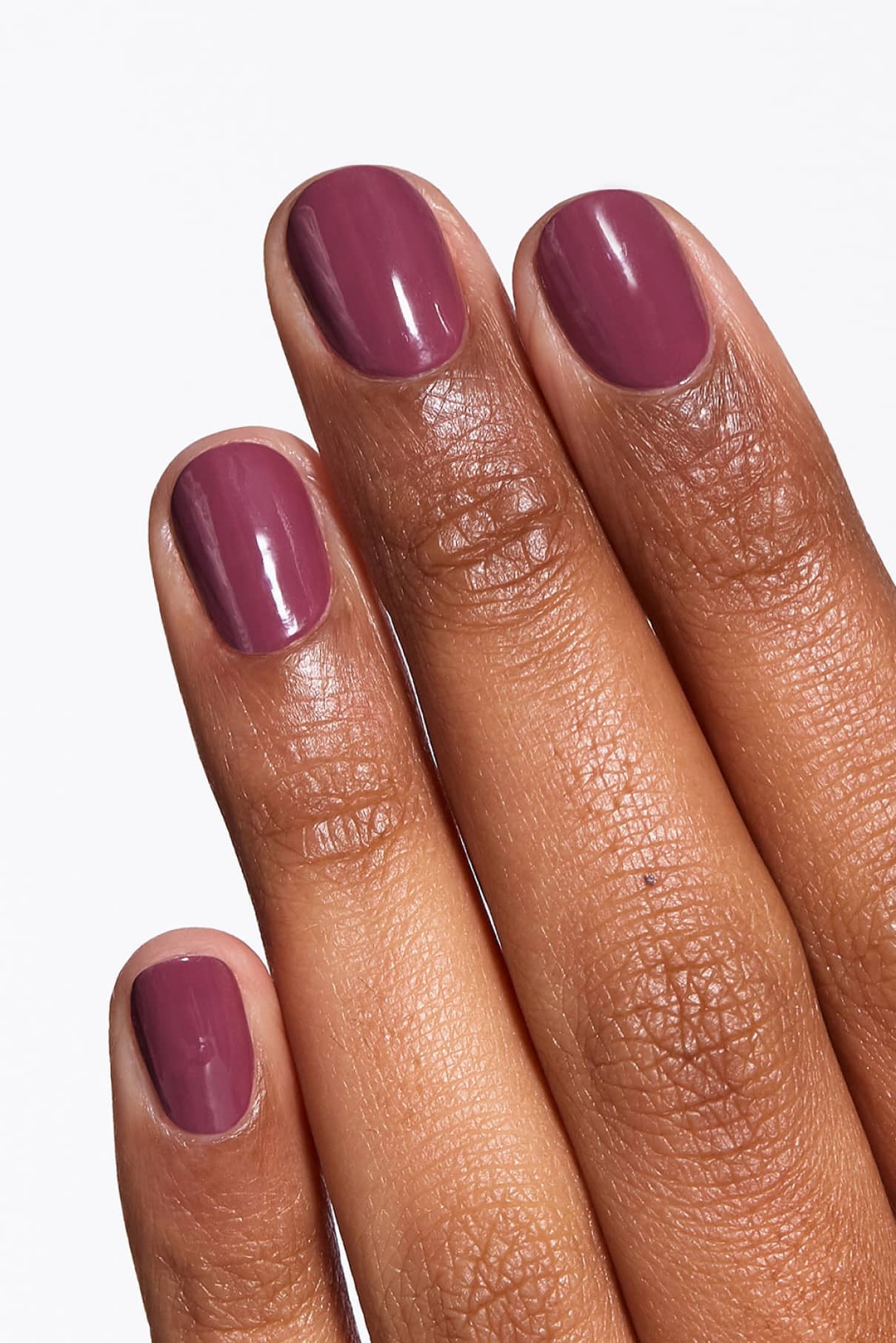 Eine Hand mit kurzen, sauber gefeilten Nägeln, die mit glänzendem gitti no. 128 lilafarbenem Nagellack lackiert.