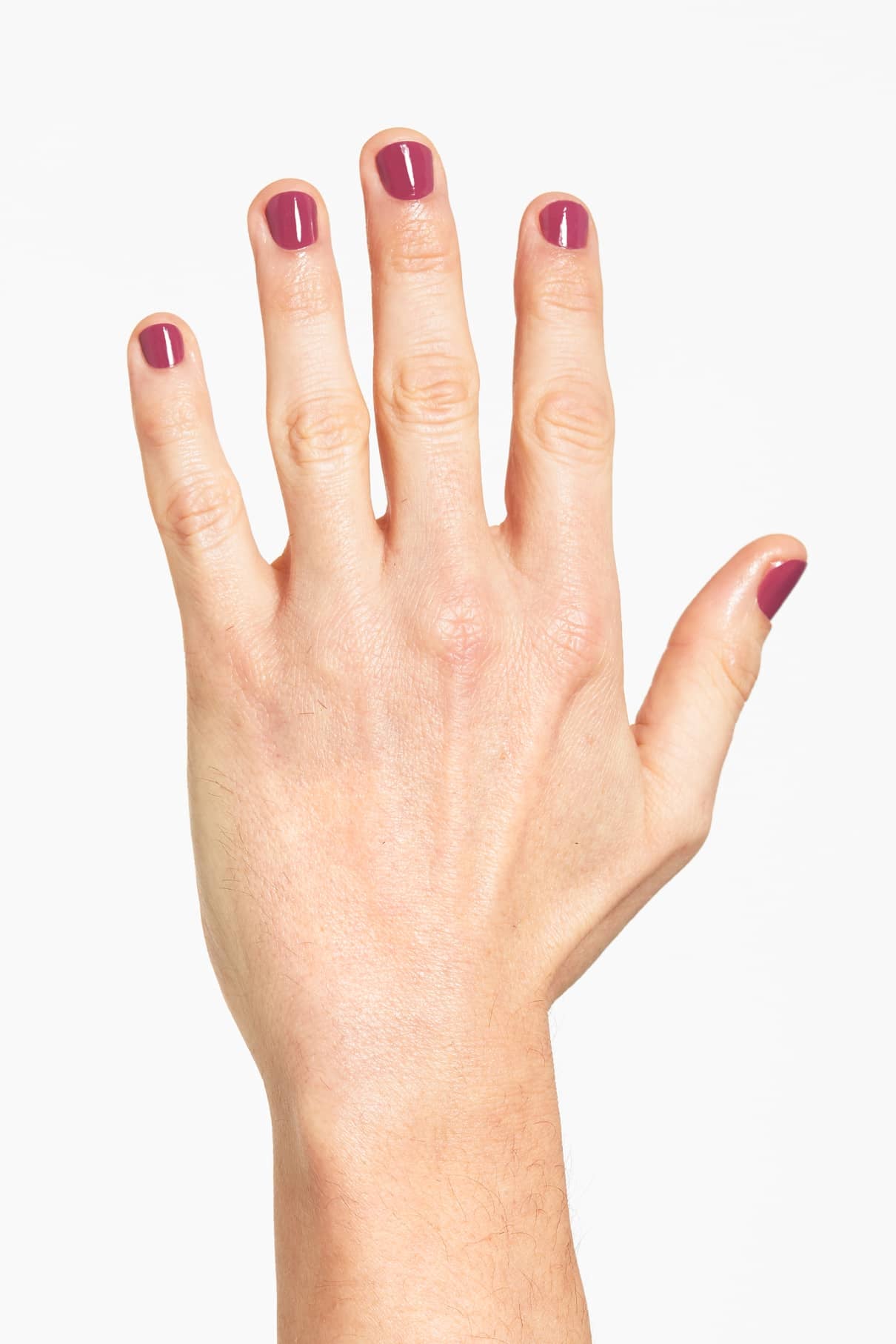 Eine linke Hand mit kurzen, sauber manikürten Nägeln, die in einem glänzenden, pastellfarbenen Lila lackiert sind (gitti Nr. 128), wird vor einem schlichten weißen Hintergrund gezeigt.