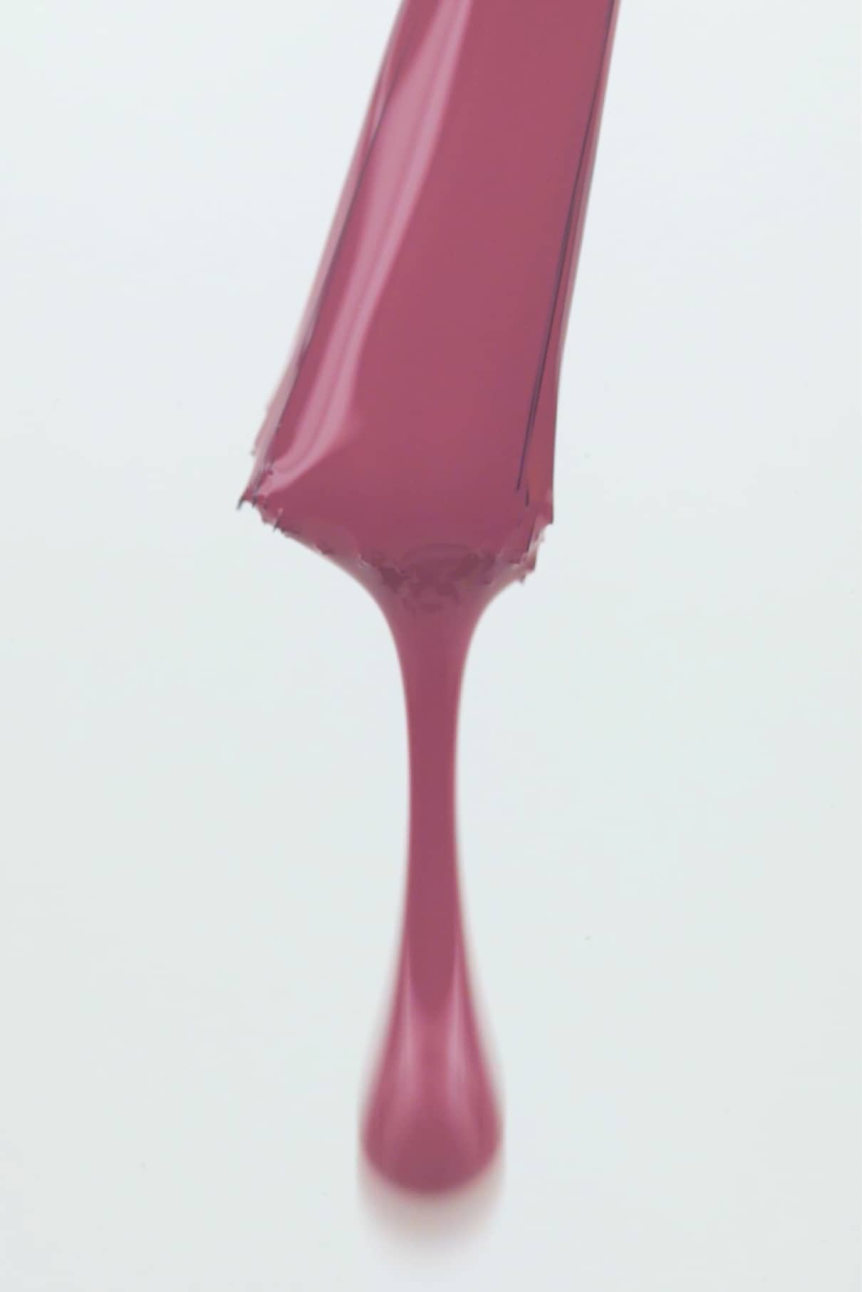 Ein Streifen des gitti no. 128 flüssiger Lippenstift in Pastelllila tropft vor einem weißen Hintergrund nach unten.