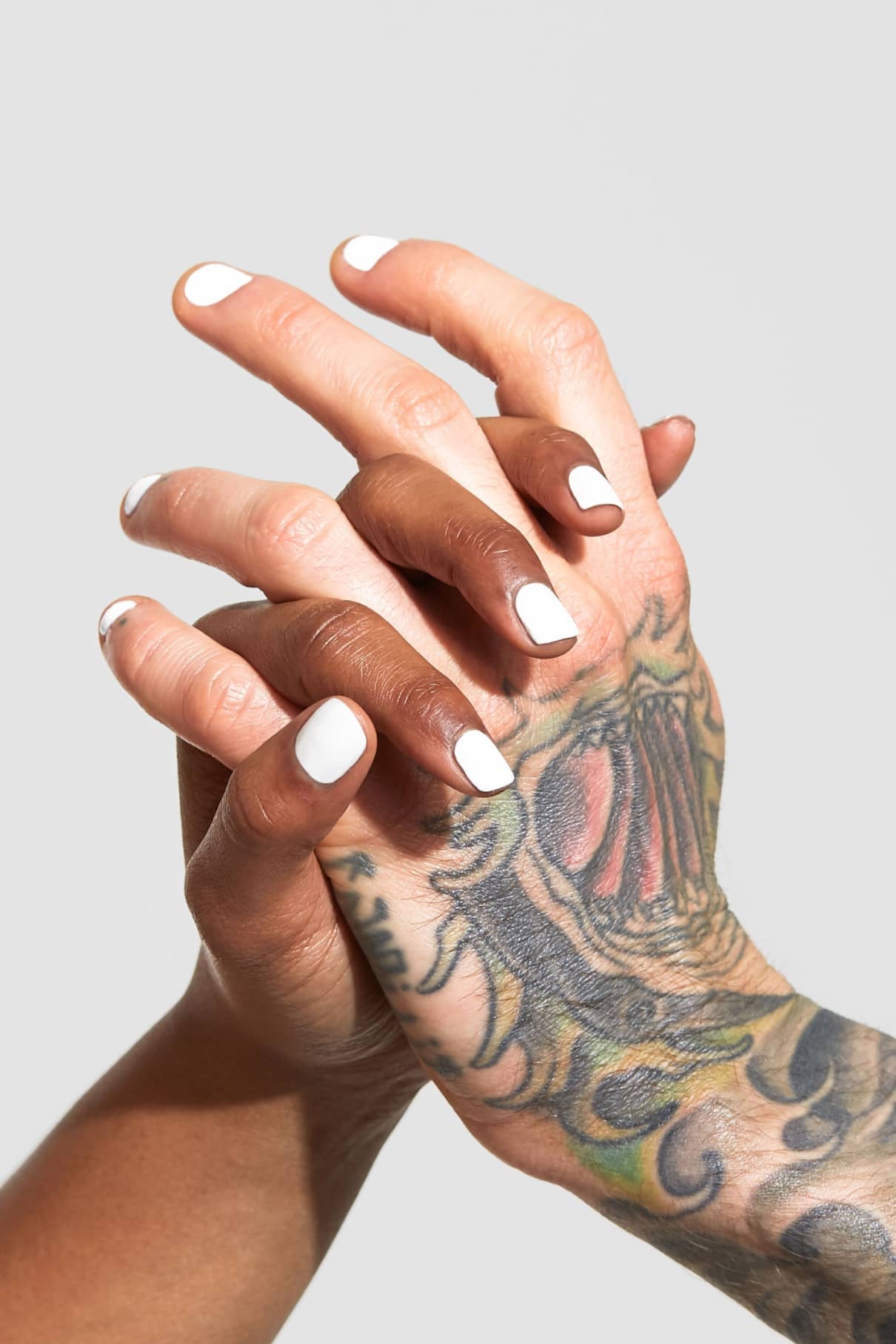 Zwei Hände mit Gitti No. 134 Nagellack verschränken die Finger; eine Hand ist tätowiert, die andere hat einen mittelbraunen Hautton.