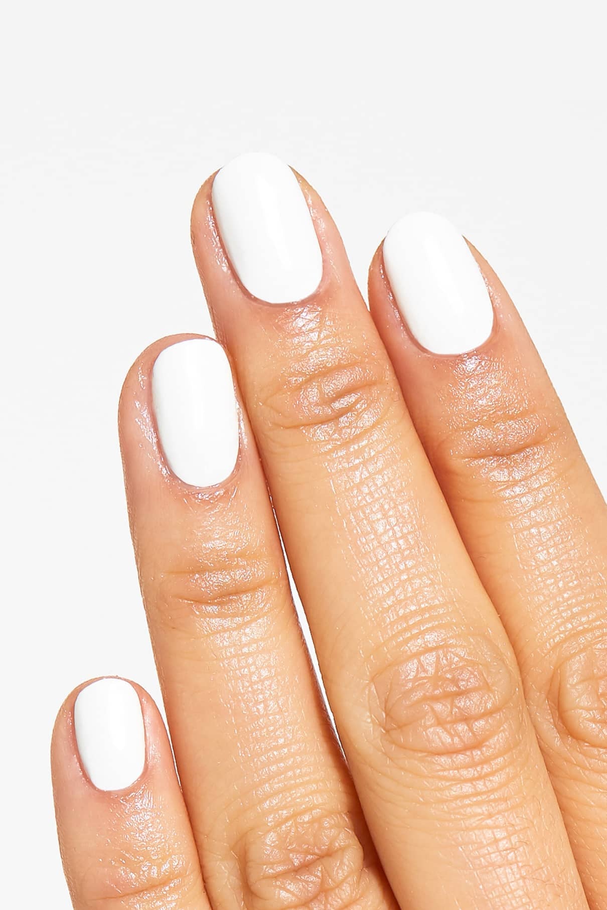 Eine Hand mit vier sichtbaren Fingern zeigt kurze, sauber manikürte Nägel, die mit glänzendem gitti no. 134, einem minimalistischen weißen Nagellack, lackiert sind.