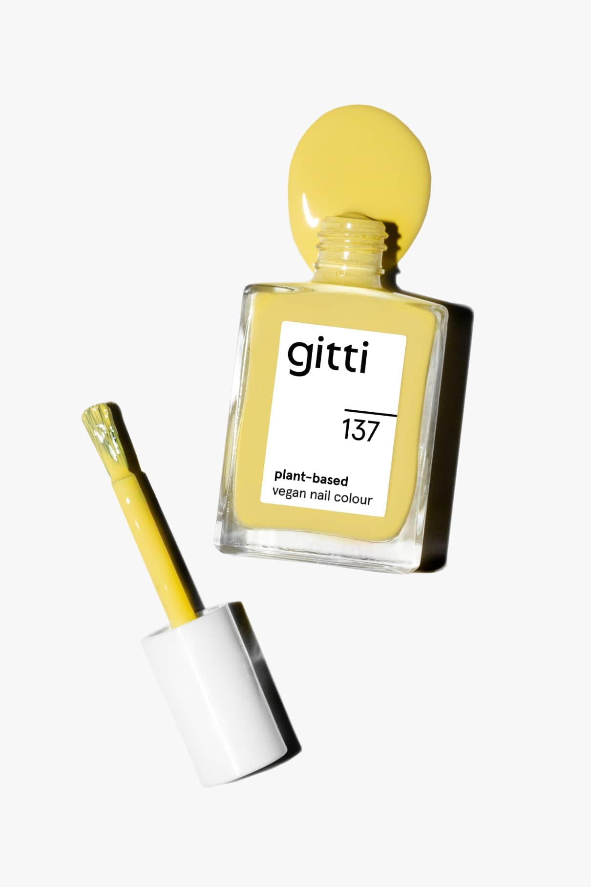 Eine Flasche gitti no. 137 pflanzlicher veganer Nagellack, Farbton leuchtendes Gelb, geöffnet mit dem Pinselapplikator daneben auf weißem Hintergrund.
