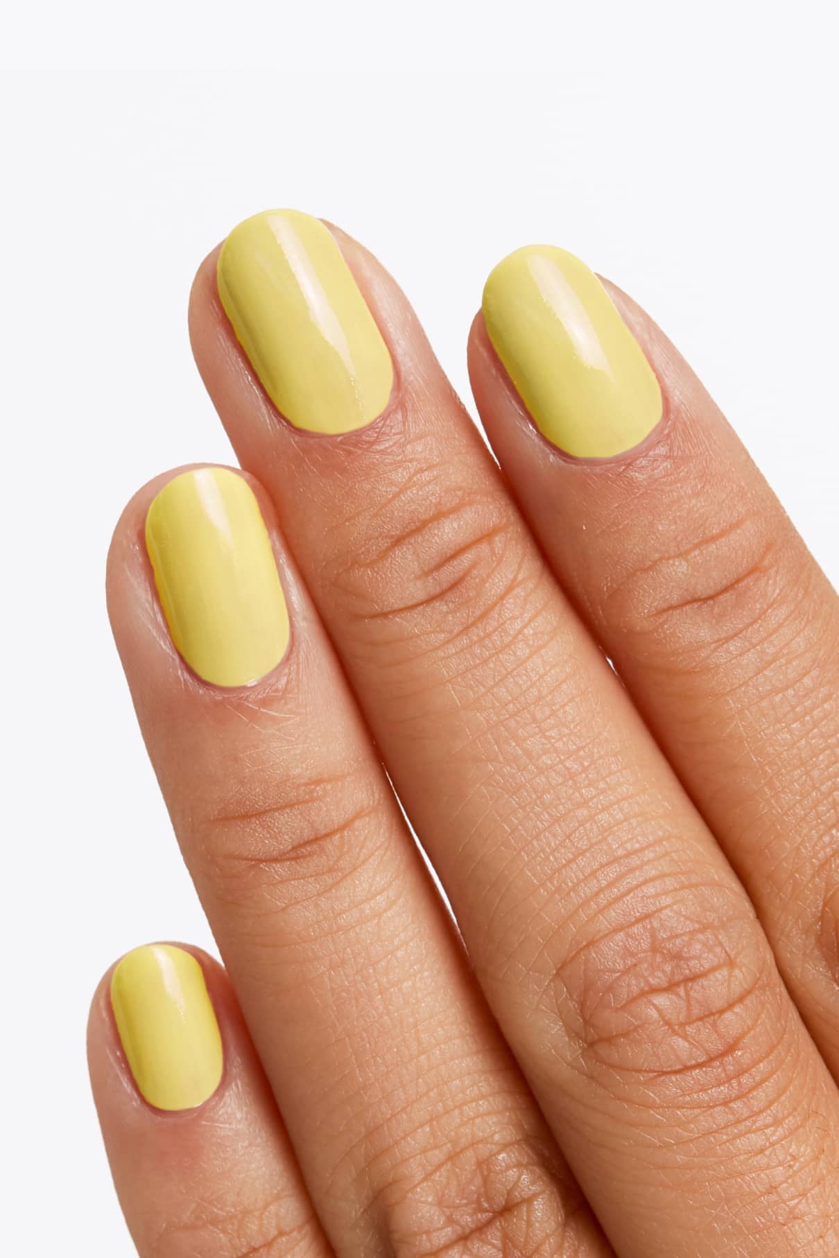 Nahaufnahme einer Hand mit kurzen, sauber manikürten Nägeln, die in gitti no. 137, einem glänzenden leuchtenden Gelbton, für einen frischen und lebendigen Look.