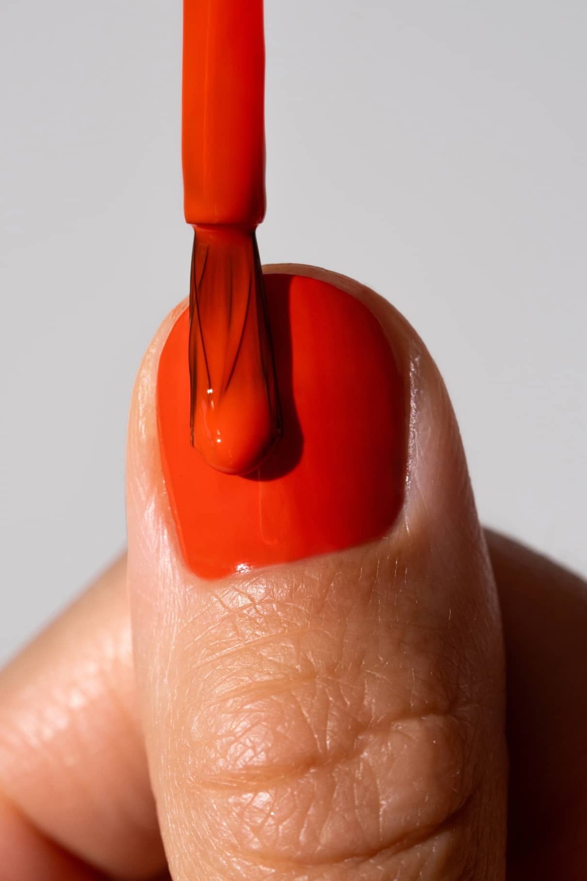 Nahaufnahme eines Daumennagels, der mit gitti no. 139 Nagellack mit einem Pinsel lackiert wird.