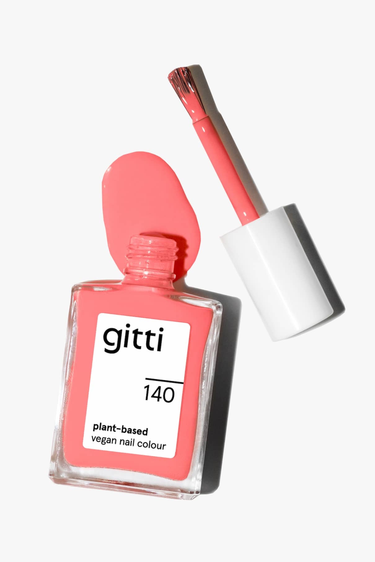 Eine Flasche von gitti no. 140, ein veganer Nagellack auf Pflanzenbasis, mit abgenommener Kappe und Pinsel, zeigt einen rosafarbenen Lack mit einem rosigen Unterton und einem leichten Korallenton.