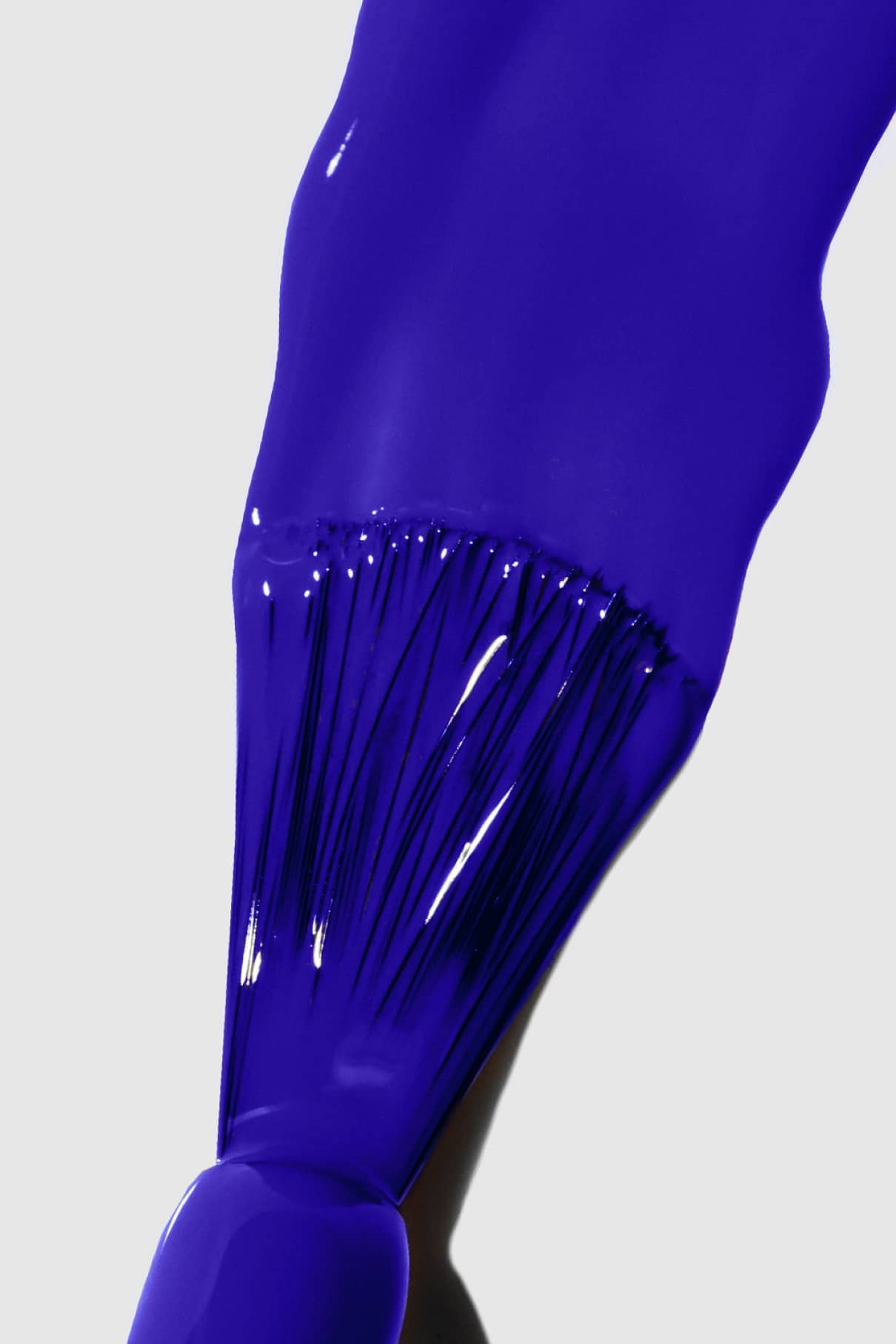 Nahaufnahme eines Pinsels, mit dem gitti no. 141 Nagellack in einem intensiven Blauton mit einem glatten, gleichmäßigen Strich auf eine weiße Fläche auf.