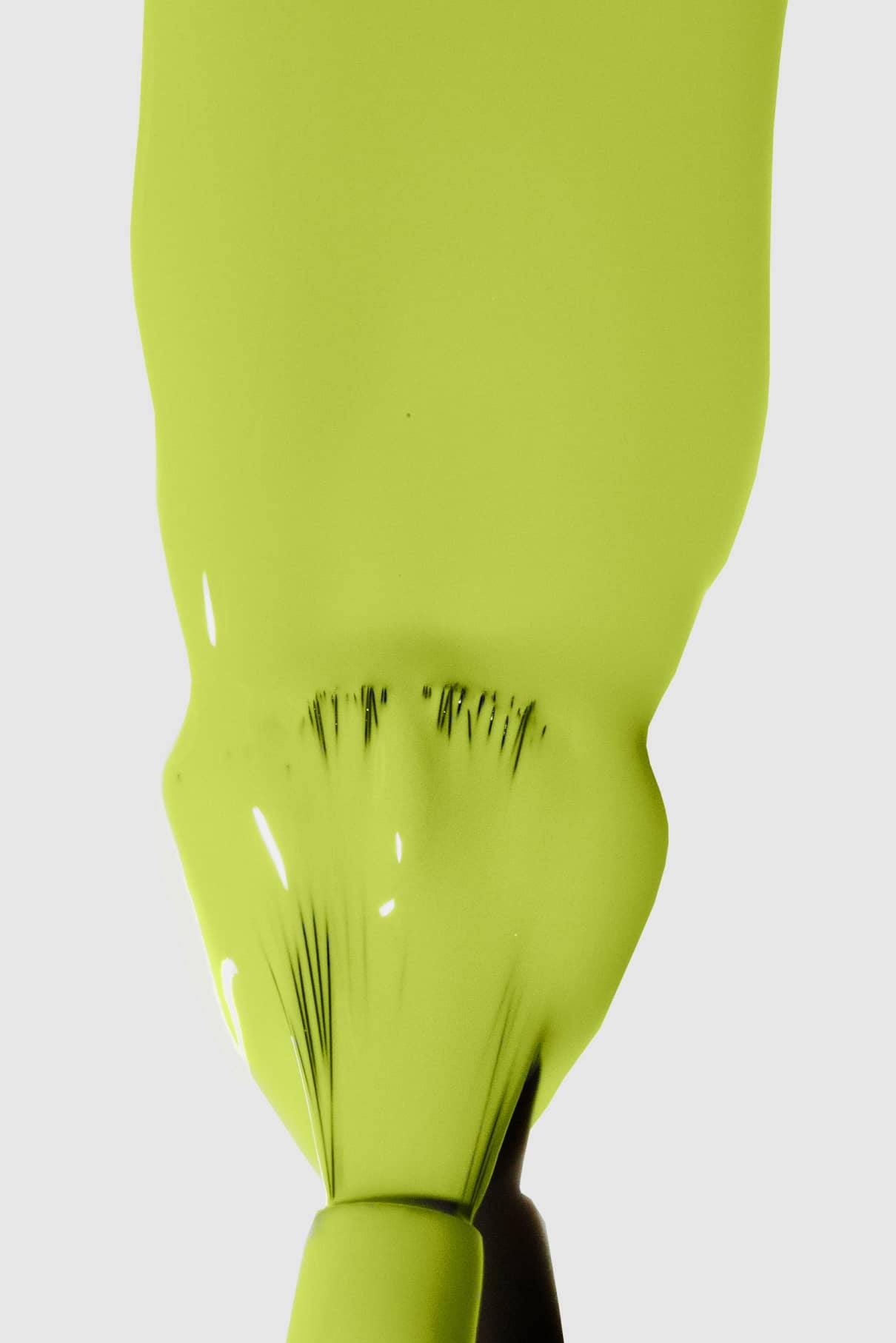 Nahaufnahme eines Pinsels, der Gitti Nr. 142, ein frischer gelbgrüner Farbton, auf einer glatten Oberfläche vor einem unifarbenen Hintergrund.