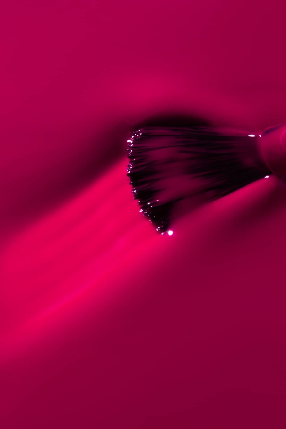 Eine Nahaufnahme eines Make-up-Pinsels, der gitti no. 143, der strukturierte Linien in leuchtendes Pink auf die lebendige Oberfläche zaubert.