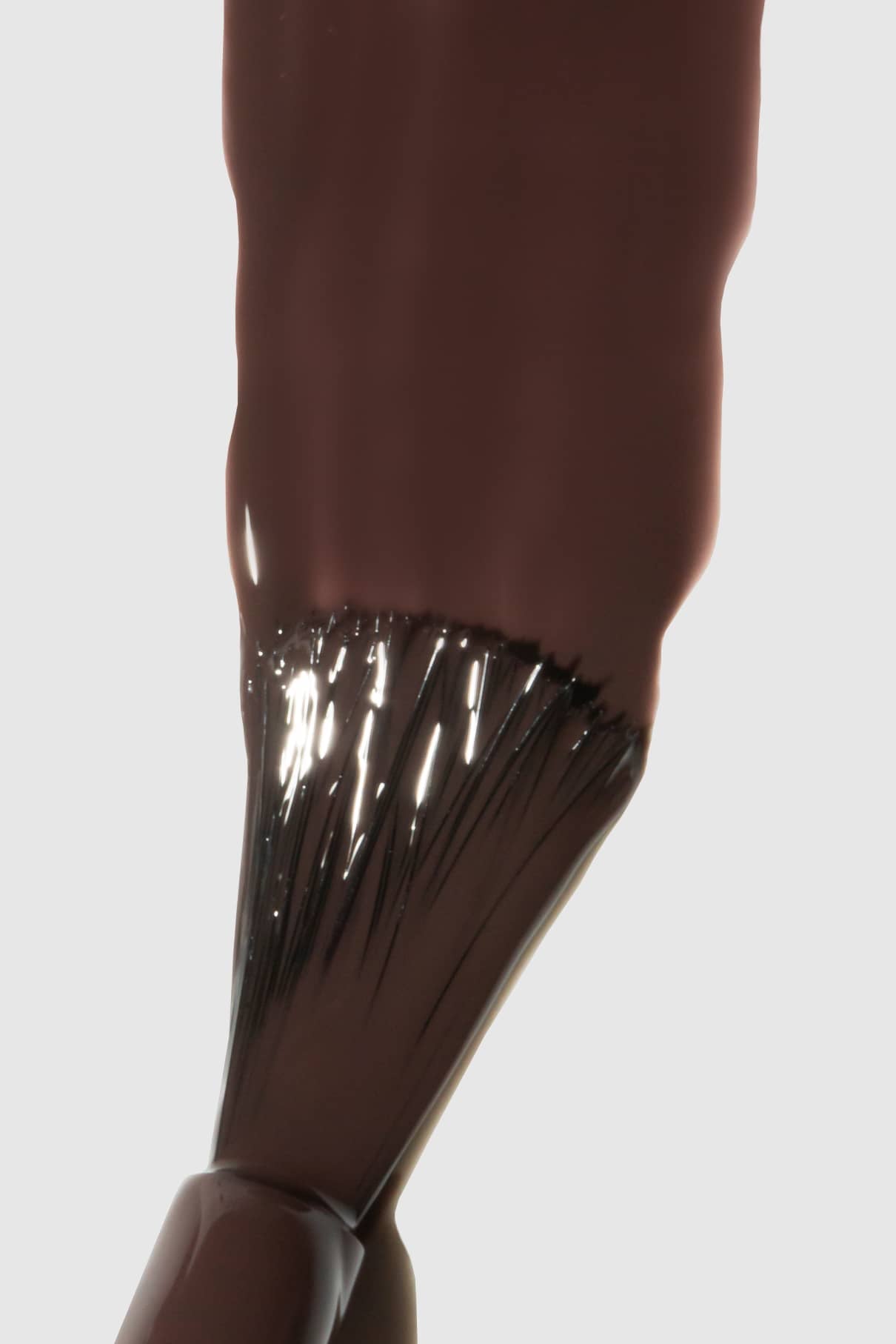 Nahaufnahme eines Nagellackpinsels, mit dem gitti no. 148, ein dunkelbrauner Nagellack in einem intensiven Braunton.