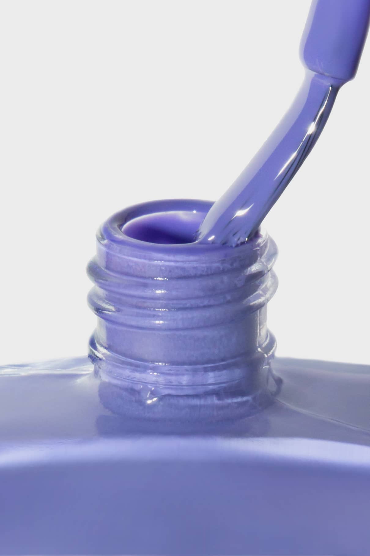 Nahaufnahme des gitti no. 152 Nagellackpinsel, der in eine geöffnete Flasche blaustichiges Violett, inspiriert von der Pantone Farbe des Jahres 2022, vor einem weißen Hintergrund getaucht wird.