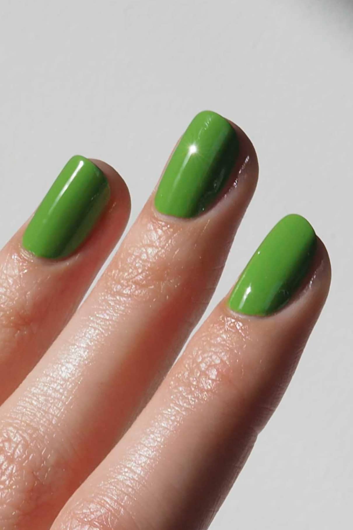 Drei Finger mit kurzen, sauber geformten Nägeln, lackiert mit glänzendem gitti no. 171 Nagellack lackiert.