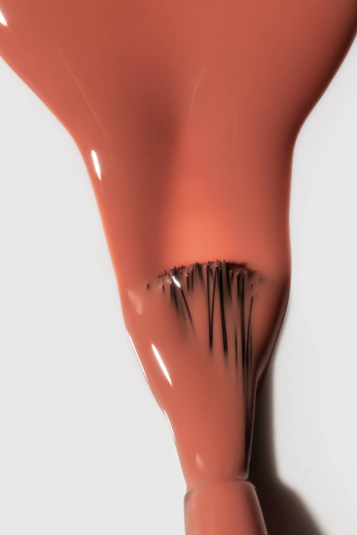 Nahaufnahme eines Nagellackpinsels, mit dem gitti no. 172, ein rosa-beiger Farbton mit warmen Untertönen, auf einer weißen Fläche.