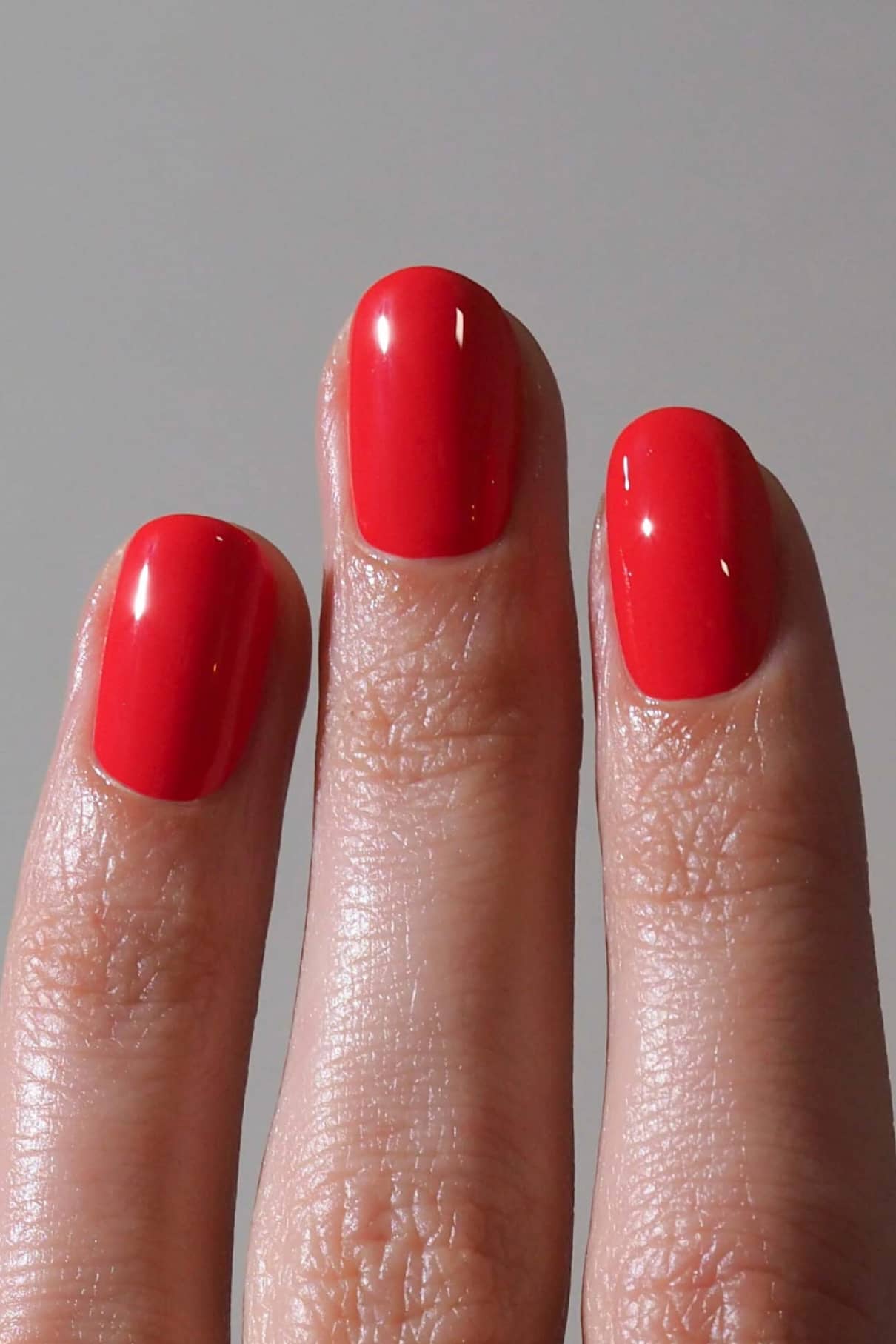 Drei Finger mit kurzen, sauber manikürten Nägeln, die in gitti no. 193 vor einem einfarbig grauen Hintergrund abgebildet sind.