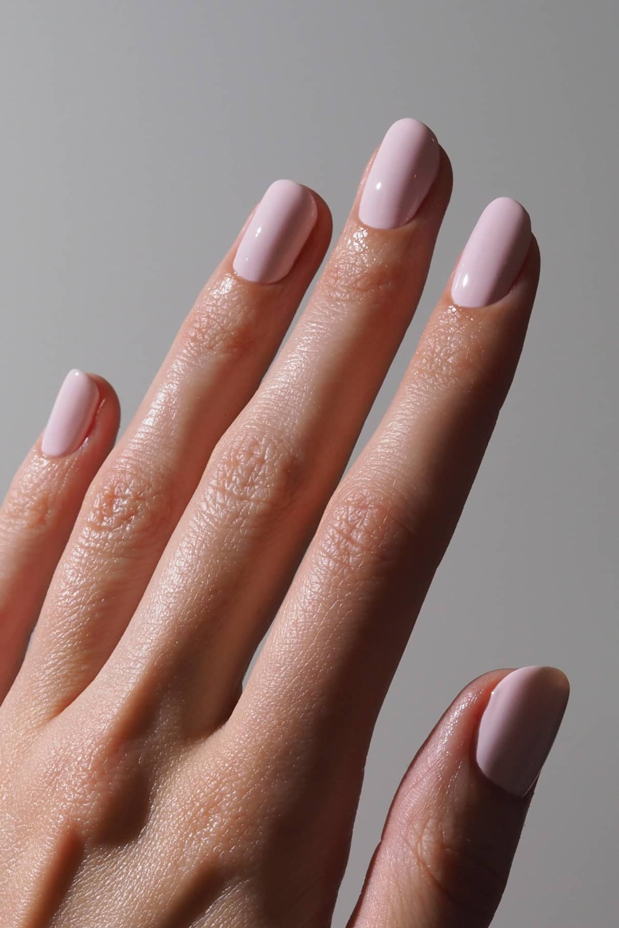 Eine Hand mit Naturnägeln, bemalt mit Gitti Nr. 198, die Finger leicht gespreizt, vor einem schlichten Hintergrund.