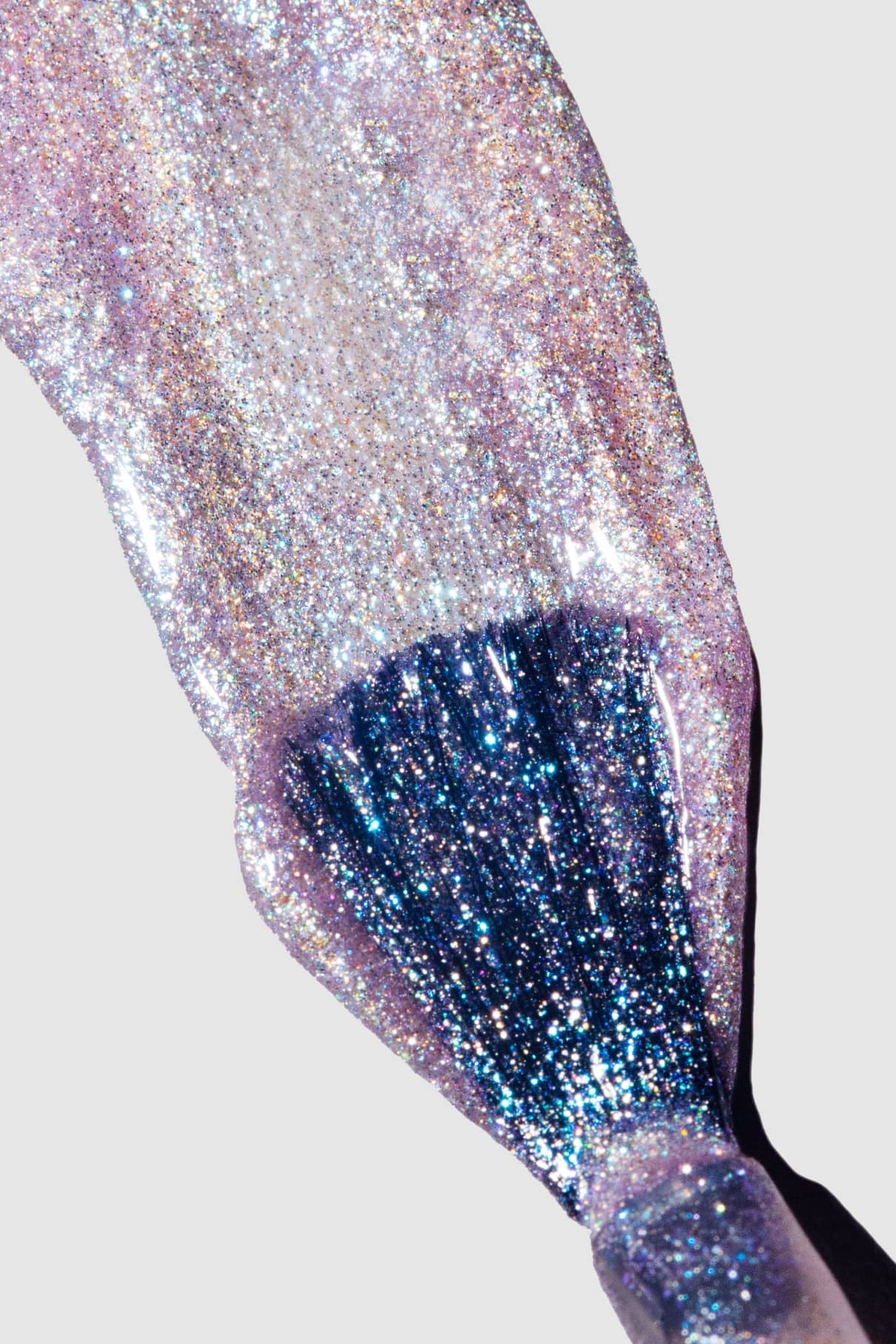 Nahaufnahme eines Nagellackpinsels, mit dem gitti no. 202, ein schimmernder, mehrfarbiger Lavendelton, auf weißem Hintergrund.