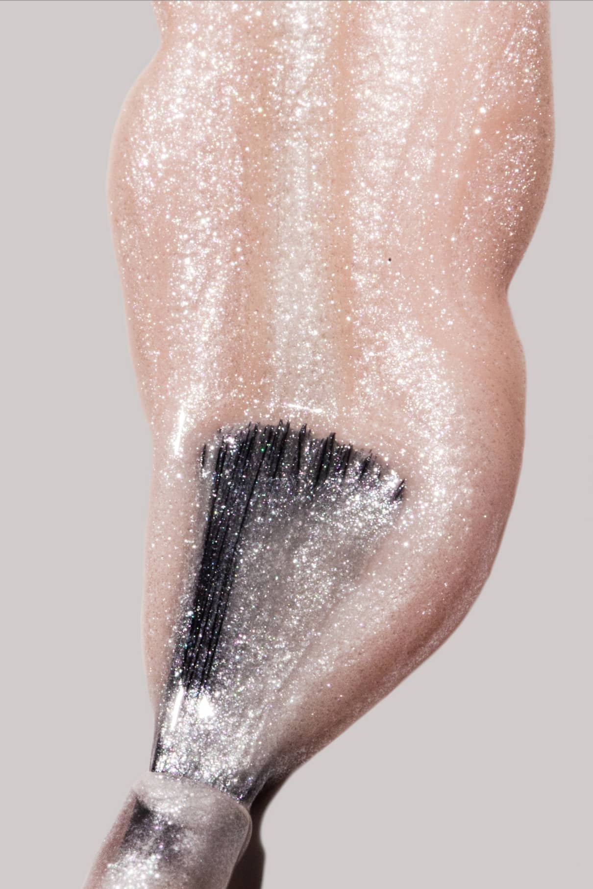 Eine Nahaufnahme eines Pinsels, mit dem gitti no. 206 - sein schimmernder, perlmuttartiger Rosaton - auf einen Fingernagel.